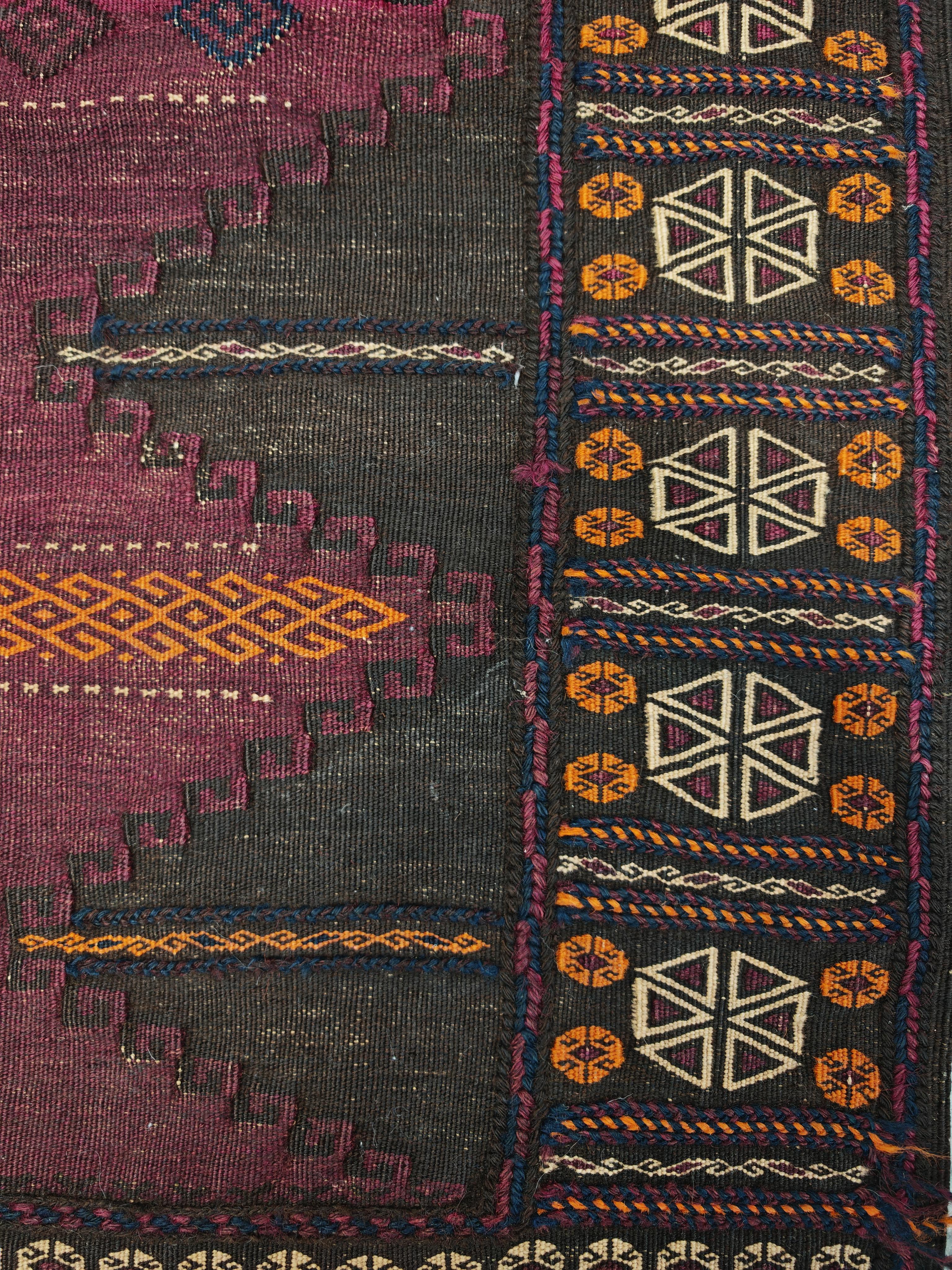 In diesem Angebot finden Sie eine wunderschöne antike Baluch Teppich handgewebt in lila Teppich. Es zeigt einfache geometrische Ornamente in Orange und Creme. Die schmalen Sumach-Fibeln sind typisch für die Belutschenstämme. Das erwähnte Farbmuster