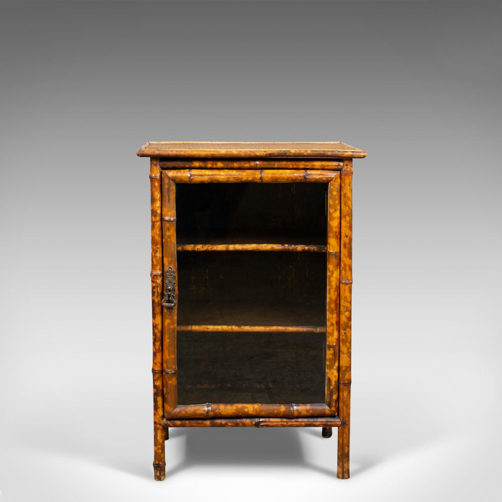 This is an antique bamboo cabinet. A Victorian, oriental bedside table with rattan top and glazed door dating to the turn of the 20th century, circa 1900.

A quality oriental cabinet presented in good antique condition
In bamboo with rattan top