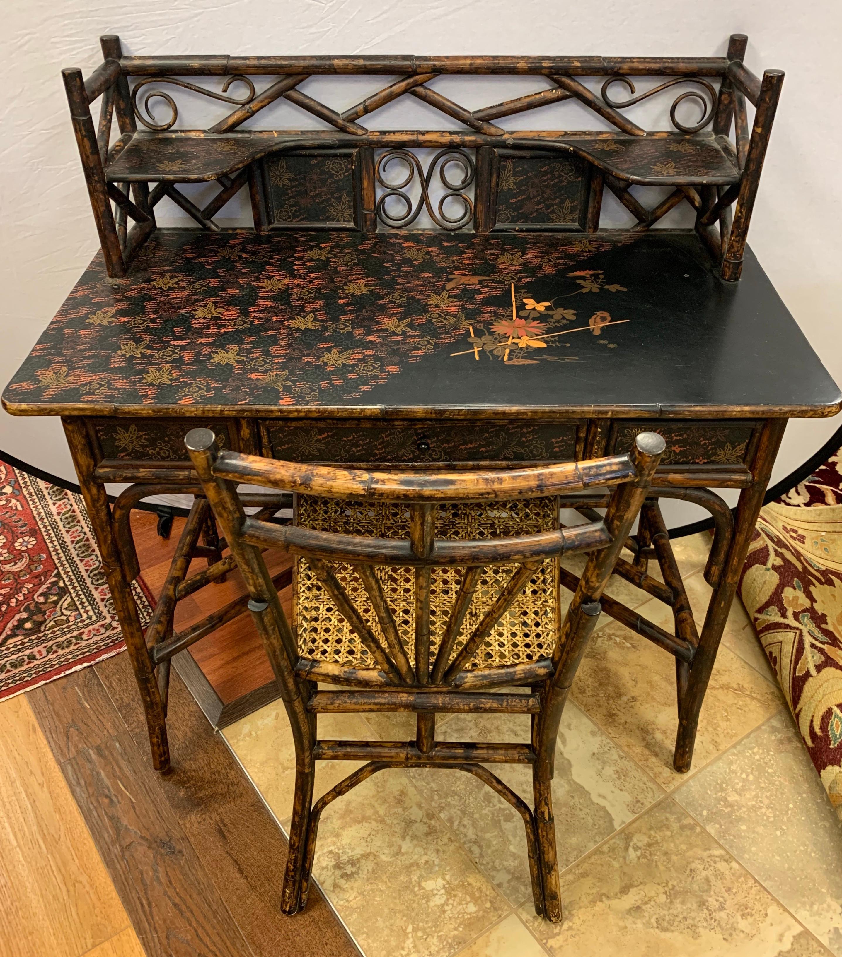 Coveted antique bamboo chinoiserie writing desk set with table and chair. The desk top is hand painted and gorgeous, circa late 19th century.