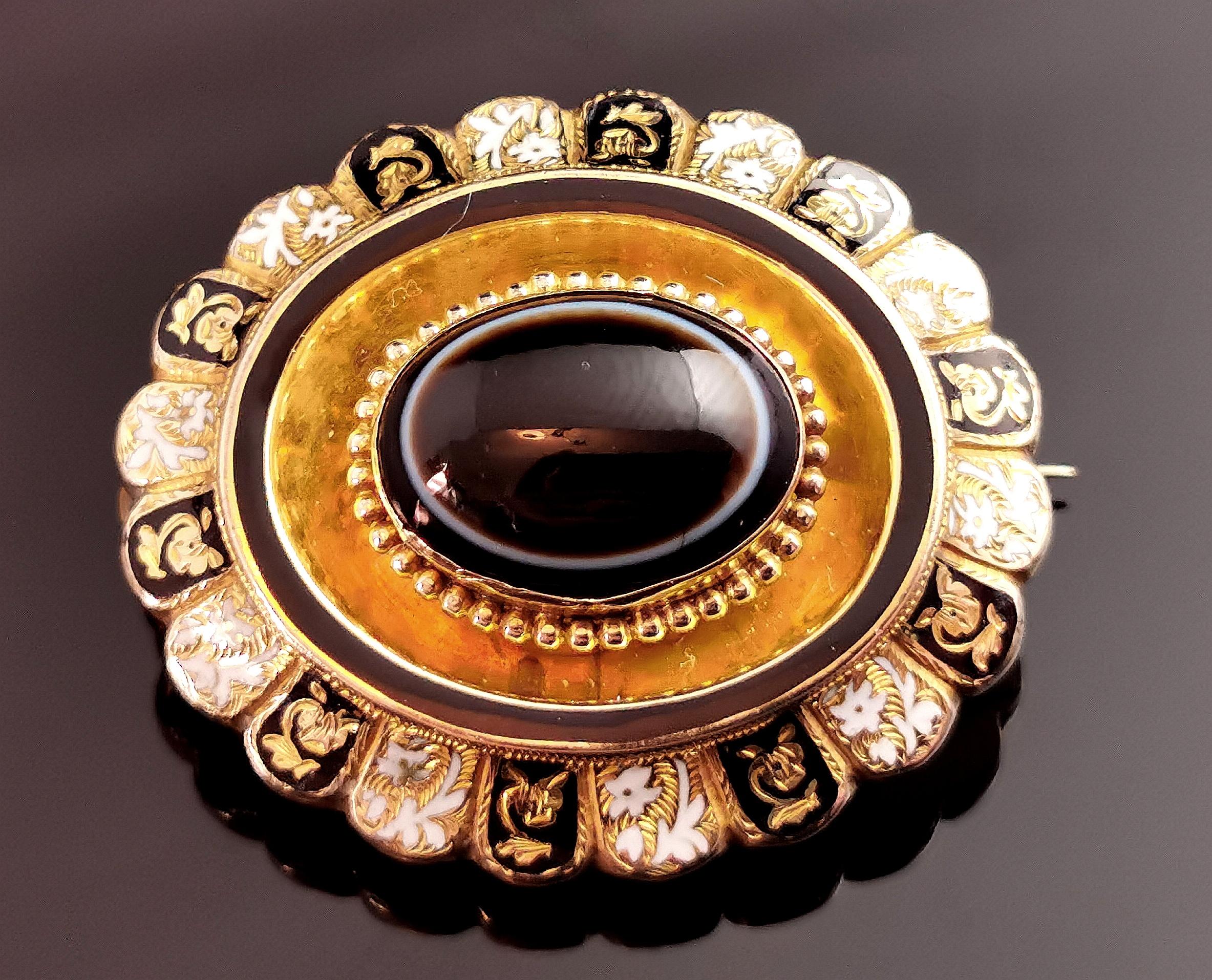 A beautiful, fine antique Victorian mourning brooch.

Crafted in 9kt gold with a rich aged patina and a bloomed gold centre setting, the brooch is an oval shape with beading and engraving.

The centre is set with a chunky banded agate cabochon, a
