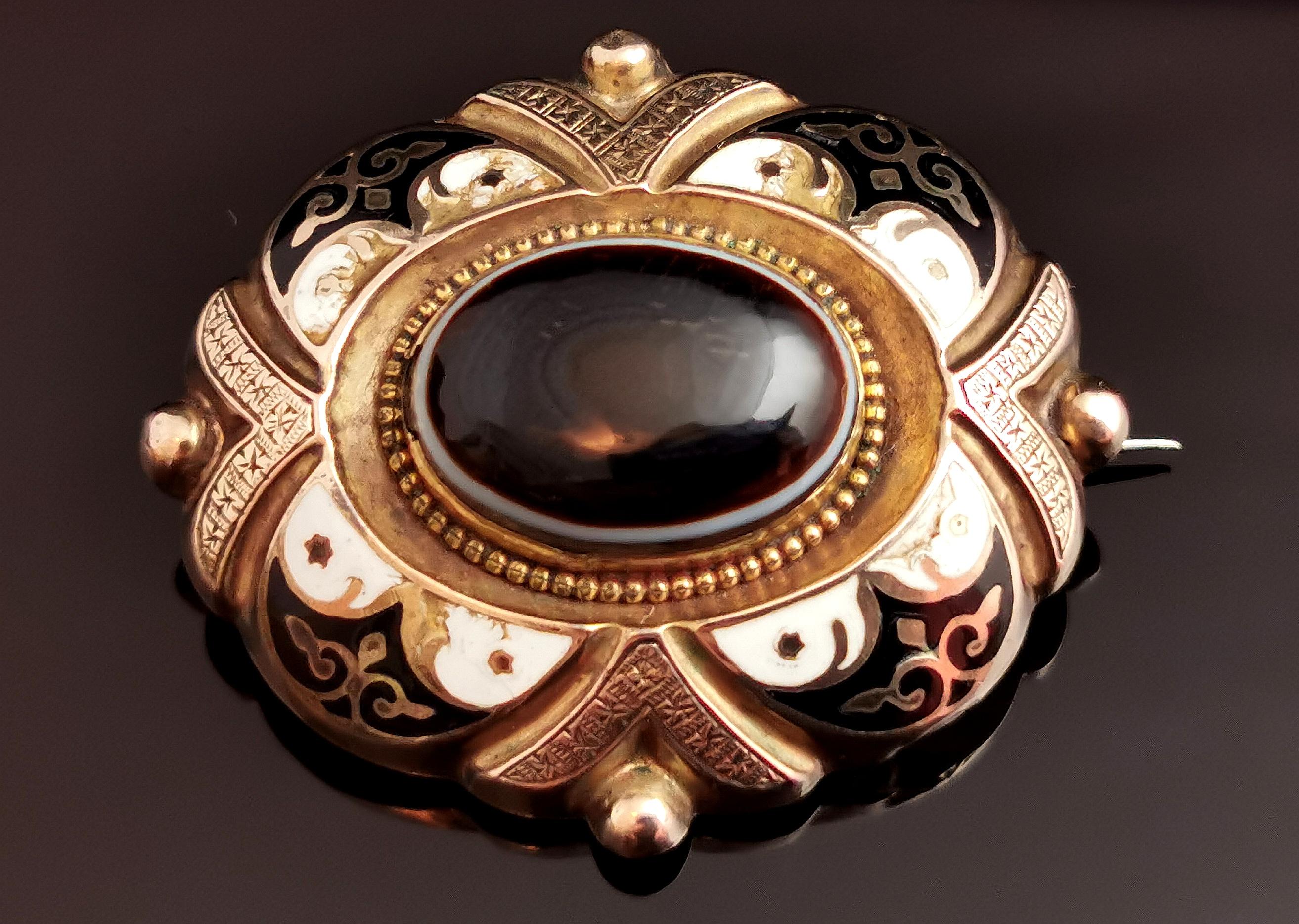 A beautiful, antique Victorian mourning brooch.

Crafted in 9ct gold with a rich aged patina, the brooch is an oval shape with beading and engraving.

The centre is set with a banded agate, a slim white band running around the base of the black /