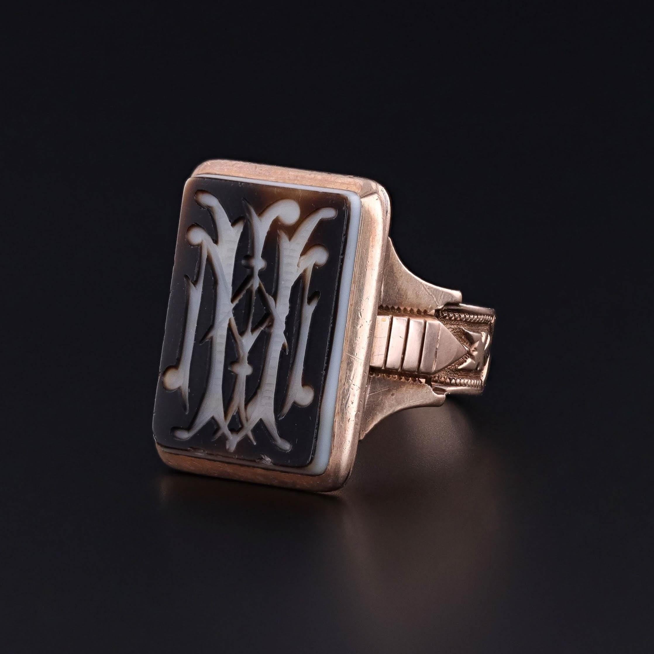 Antique Signet Ring: This antique ring dates to 1880 and features banded agate with gothic initials carved into the face.

The face of the ring measures 0.9 inches by 0.7 inches wide, and it is in great condition. The ring is a size 8.5, but it can