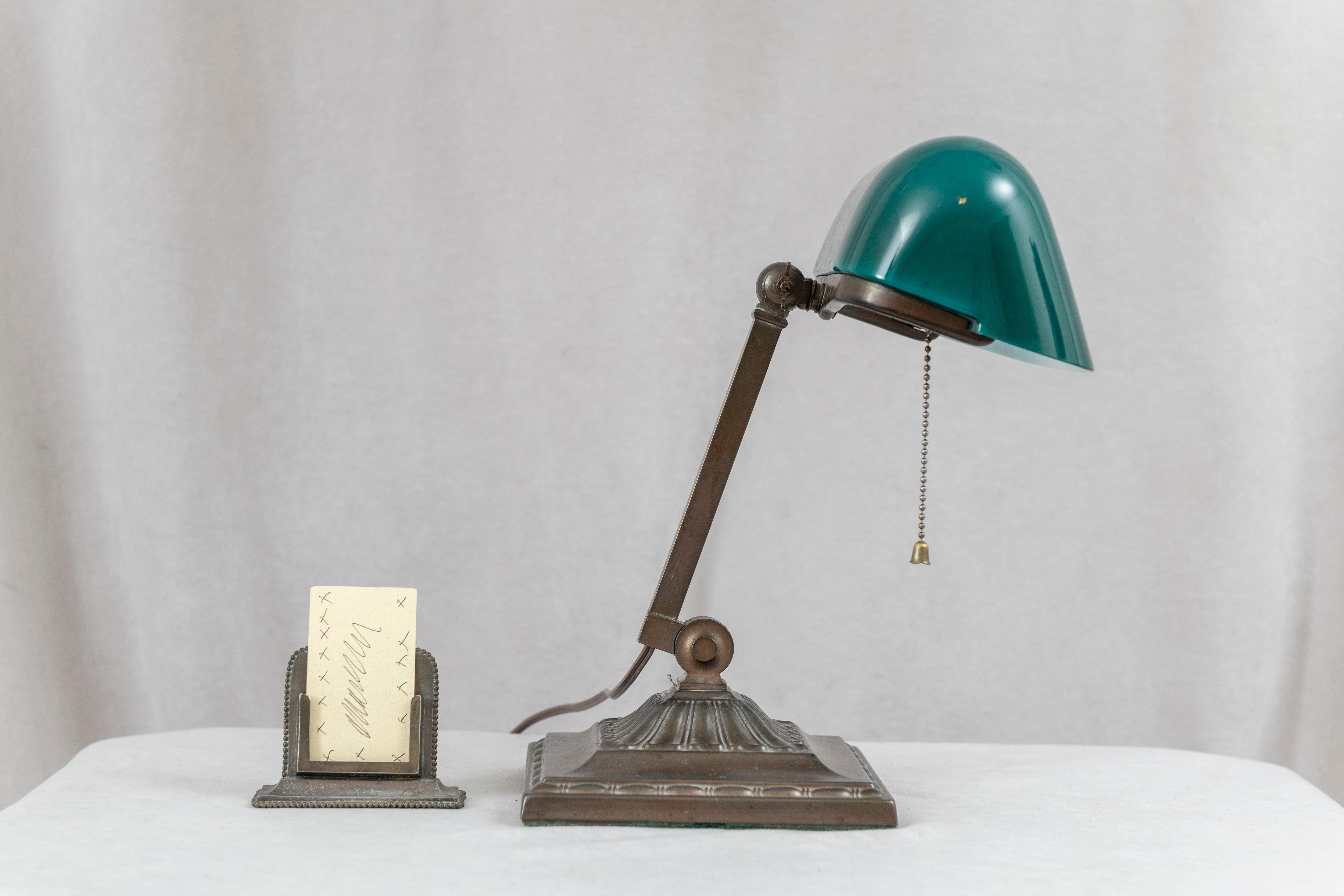  A very fine example of the genre known as banker's lamps. This example is signed by the most famous maker of these lamps, Emeralite. The shade is the original with no damage. These shades were made in 2 layers, known as cased glass. The inside