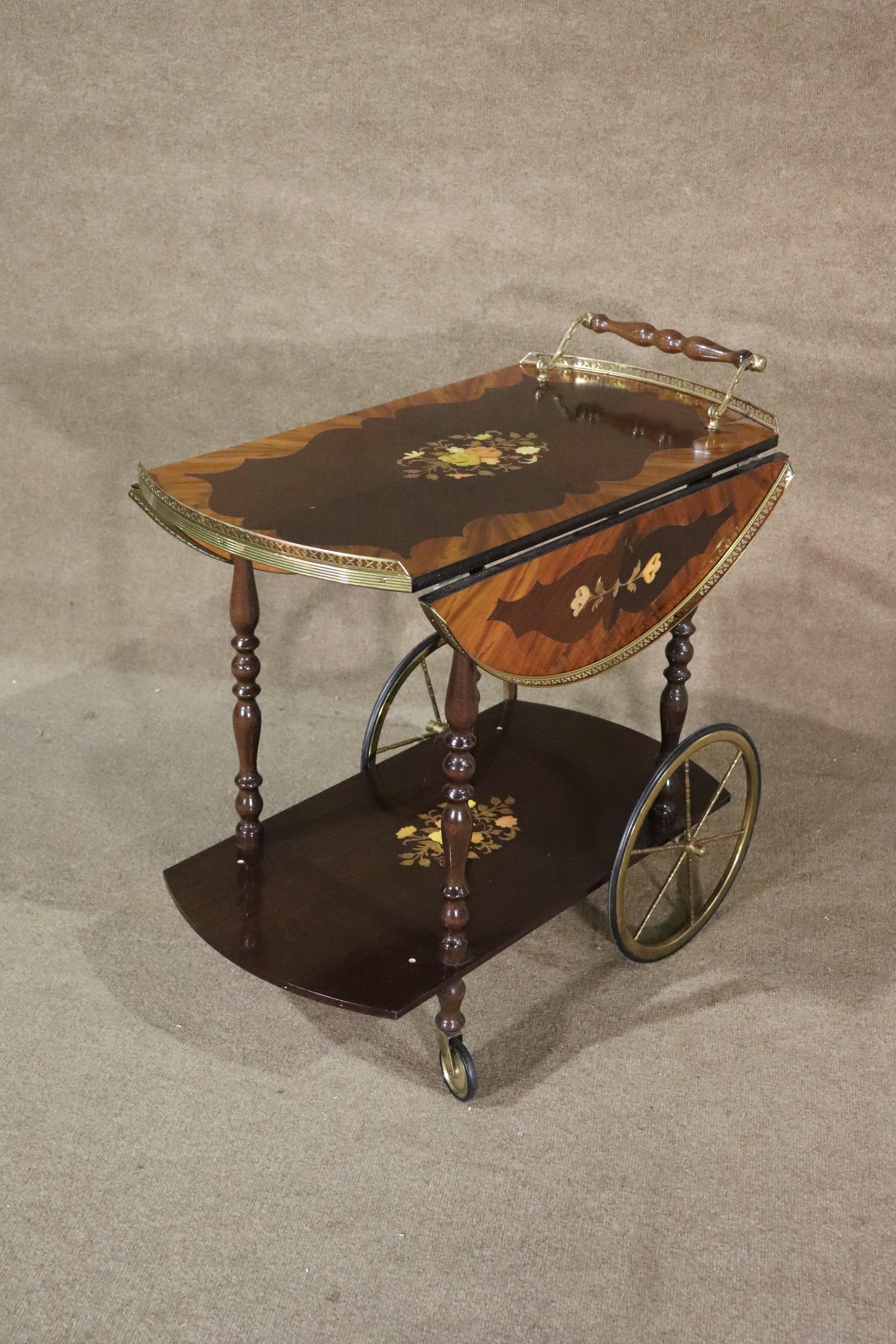 This beautiful rolling cart features an Italian style hand inlaid floral design and brass hardware. It has drop leaves that open to a round table top (29.75
