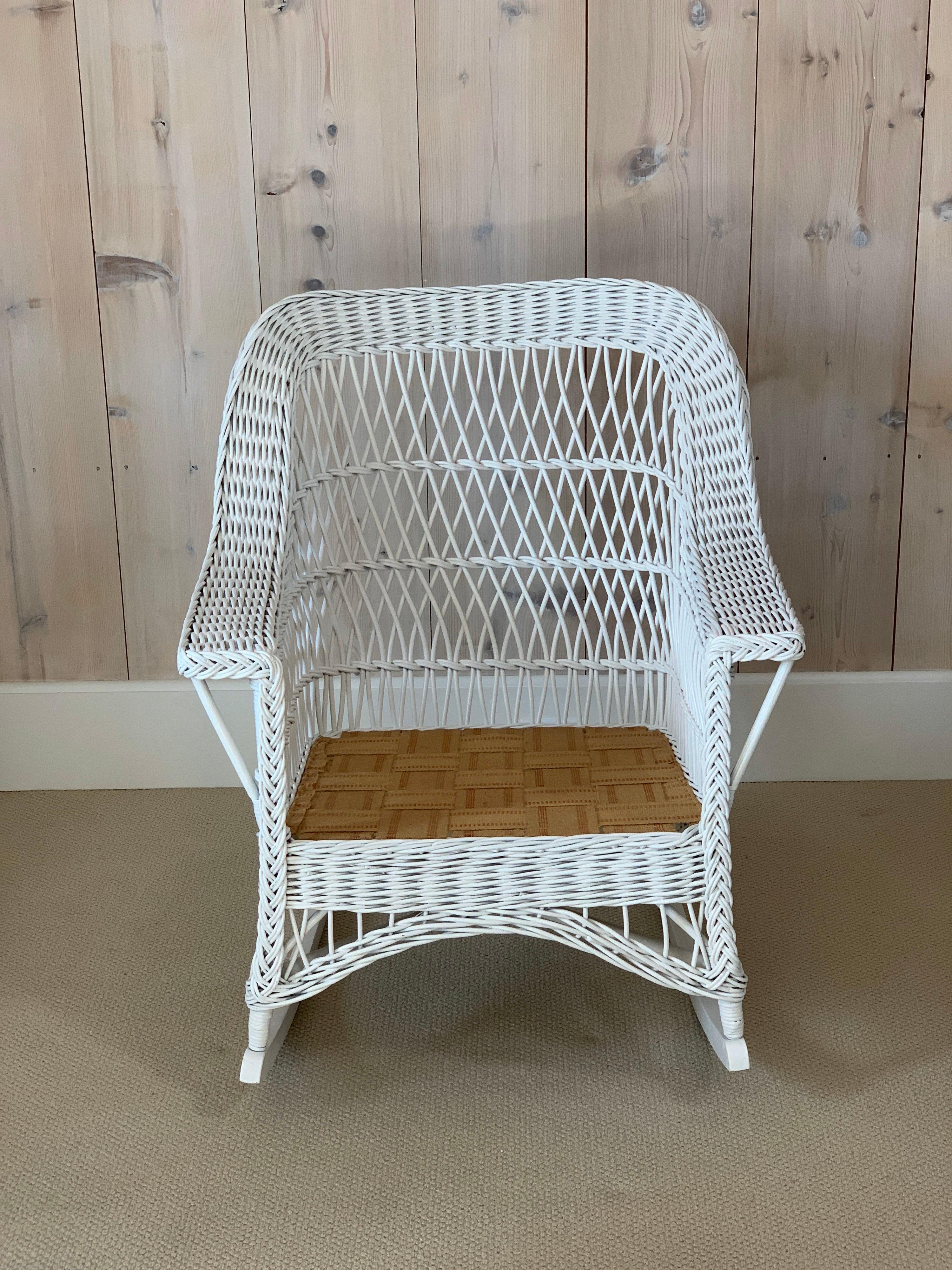 Antique Bar Harbor Rocker in fresh white paint woven of reed. Chair measures 25