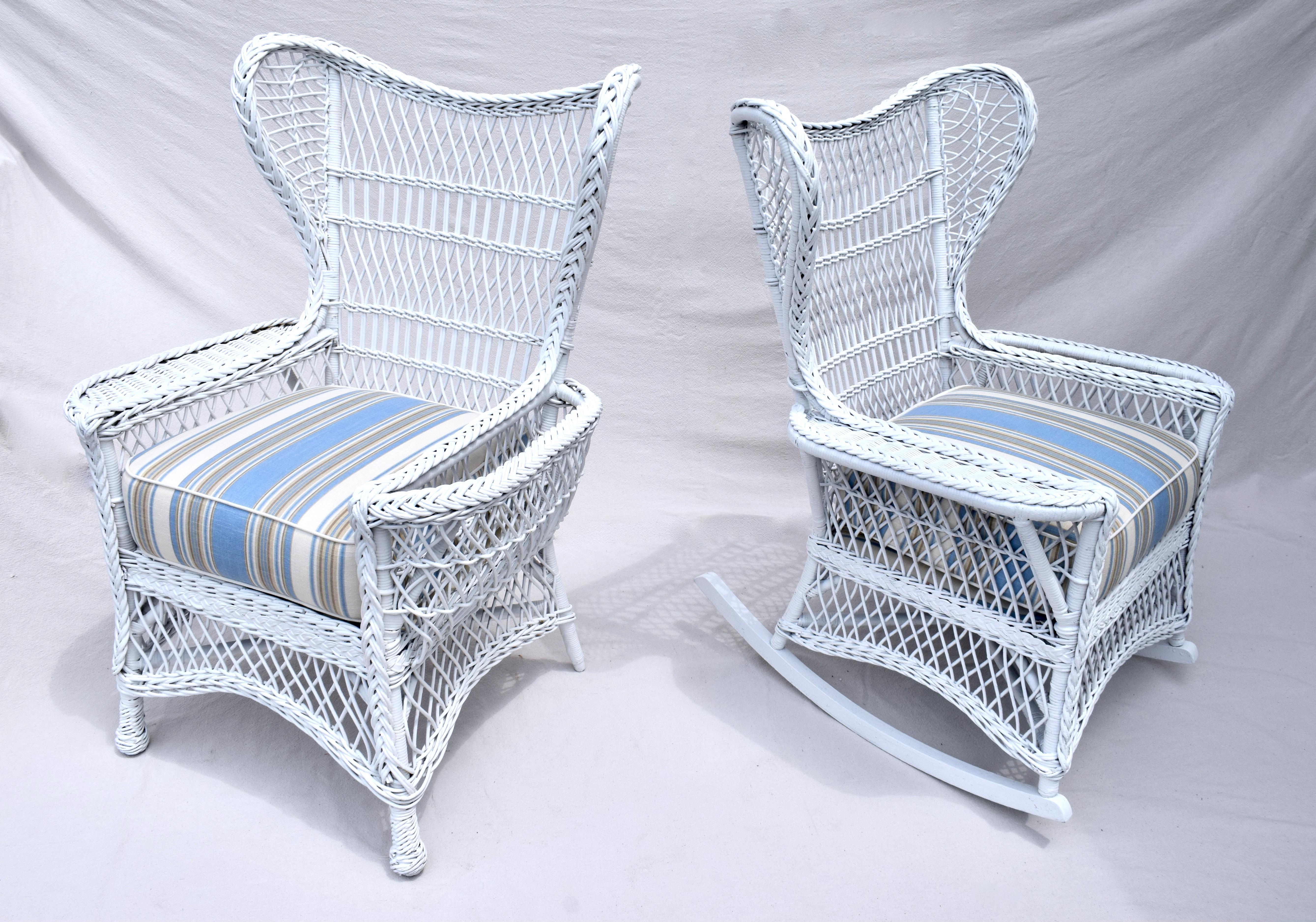 Beautifully preserved early 20th c. Americana willow and reed Bar Harbor wing back chair & matching rocker each having woven arm rest & magazine pocket newly painted with new custom cushions upholstered in blue & white coastal stripe cotton linen