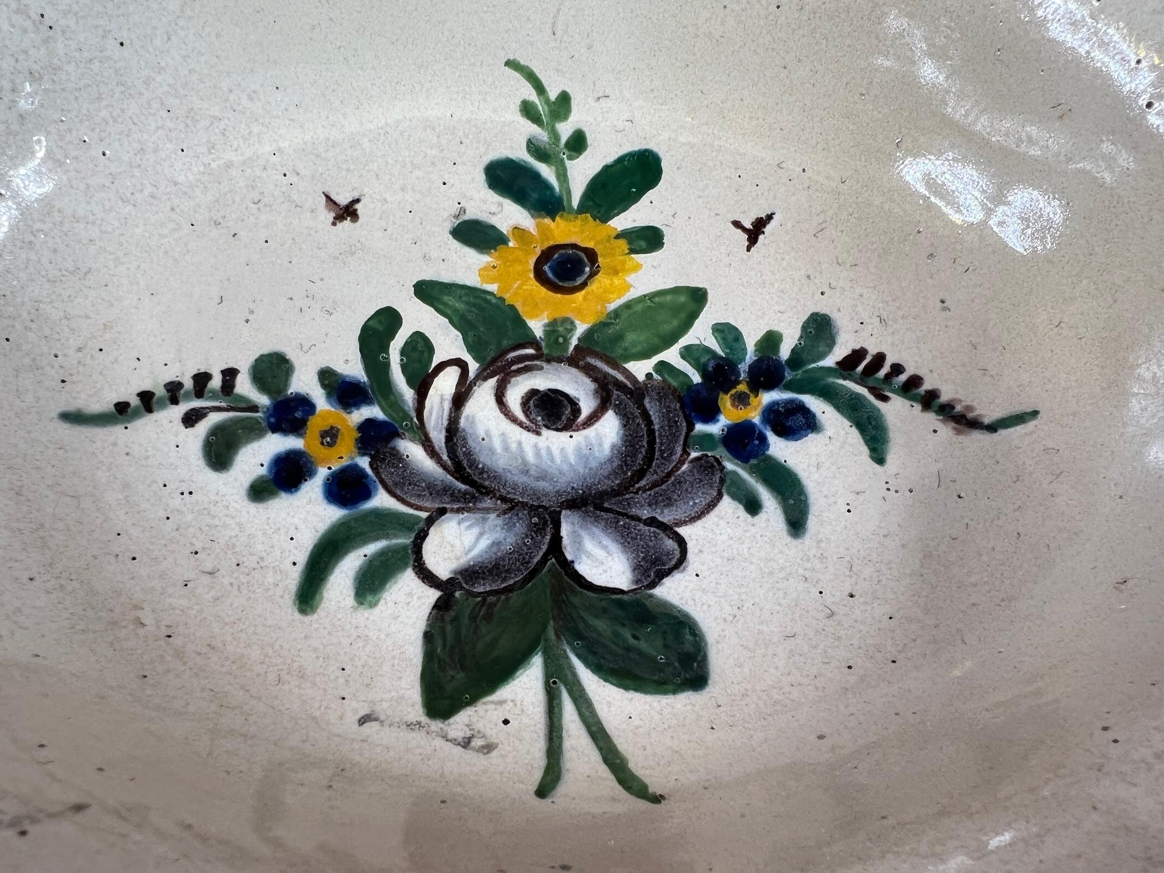 Ancient shaving dish in Nevers faience with floral decoration featuring a lovely bouquet consisting of a beautiful black rose and yellow flowers.

Dimensions:

30.5cm x 24cm (12.01 inches x 9.45 inches)
Height: 8cm (3.15 inches)

A male toilet
