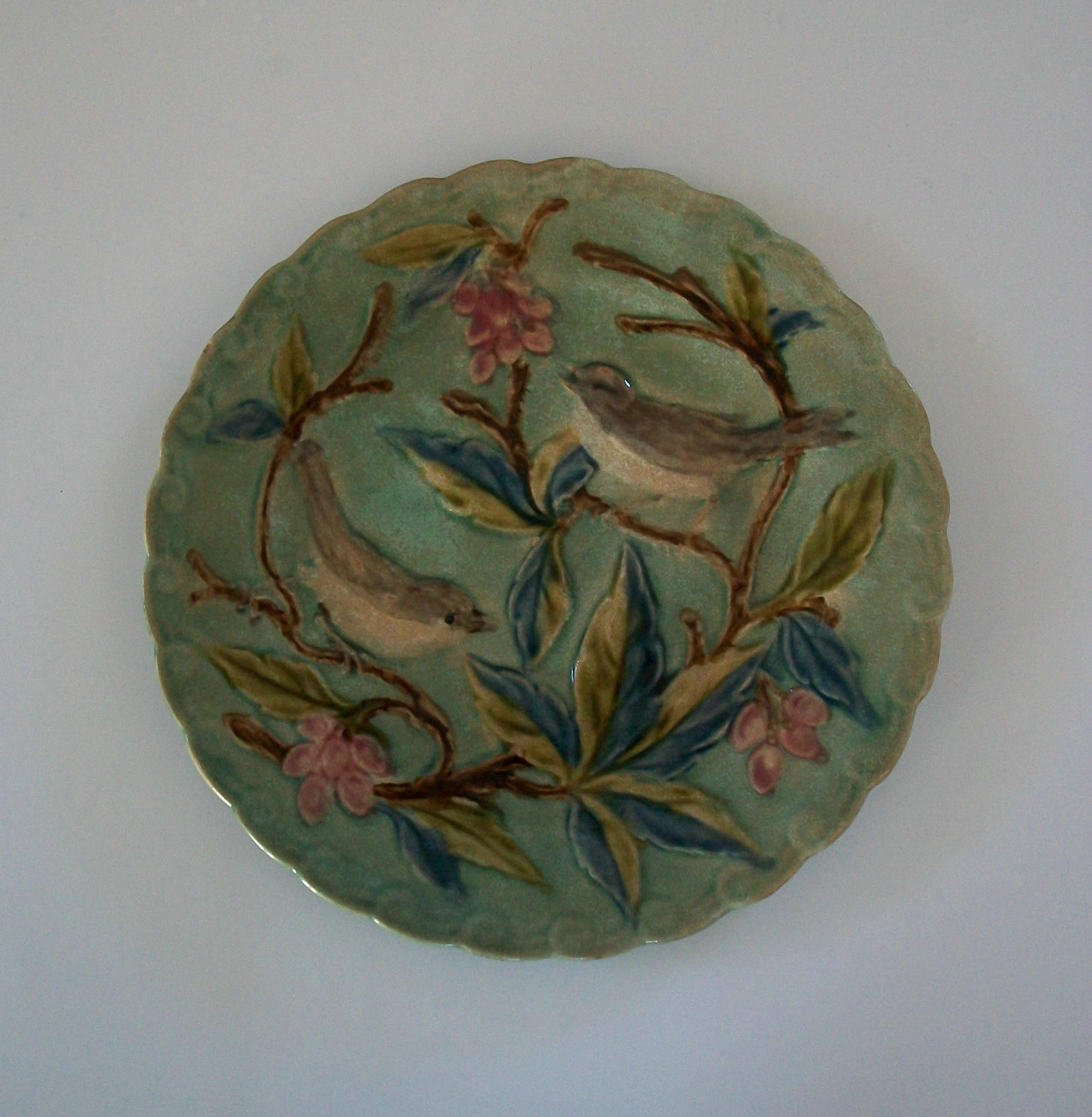 Assiette ancienne en céramique majolique de Barbotine - taille moyenne avec bord en croissant - peinture à la main sur un décor en relief d'oiseaux et de flore - non signée - France - fin du 19ème siècle. 

Excellent/mint état vintage - pas de perte