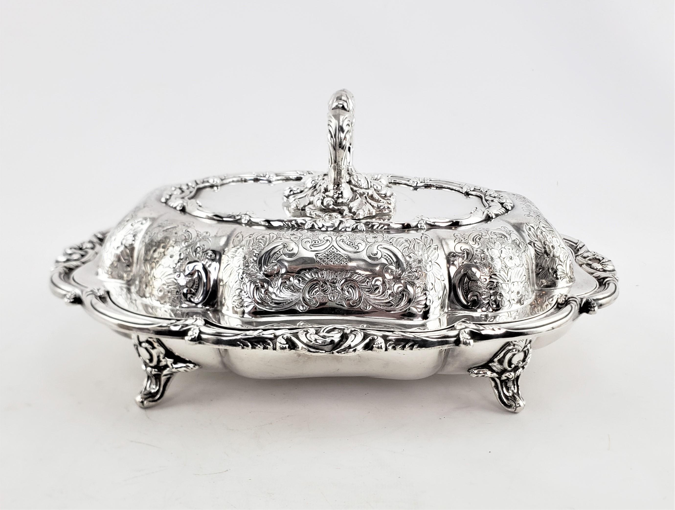 This antique silver plated covered server was made by the well known Barker Brothers of England in approximately 1880 and done in a period Victorian style. This entree server has a raised scalloped shaped top with a removable cast and plated handle