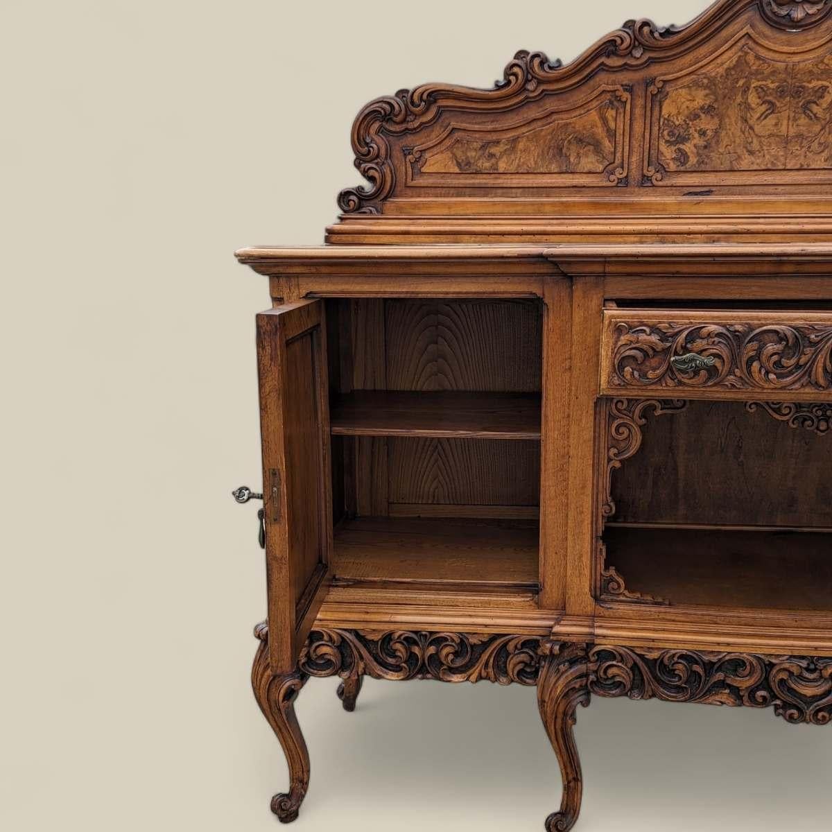Antique armoire baroque en bois sculpté

Ce buffet antique en bois sculpté de style baroque illustre l'opulence et la complexité de l'artisanat de l'époque baroque. Construit en chêne ou en noyer massif, il présente des sculptures élaborées qui