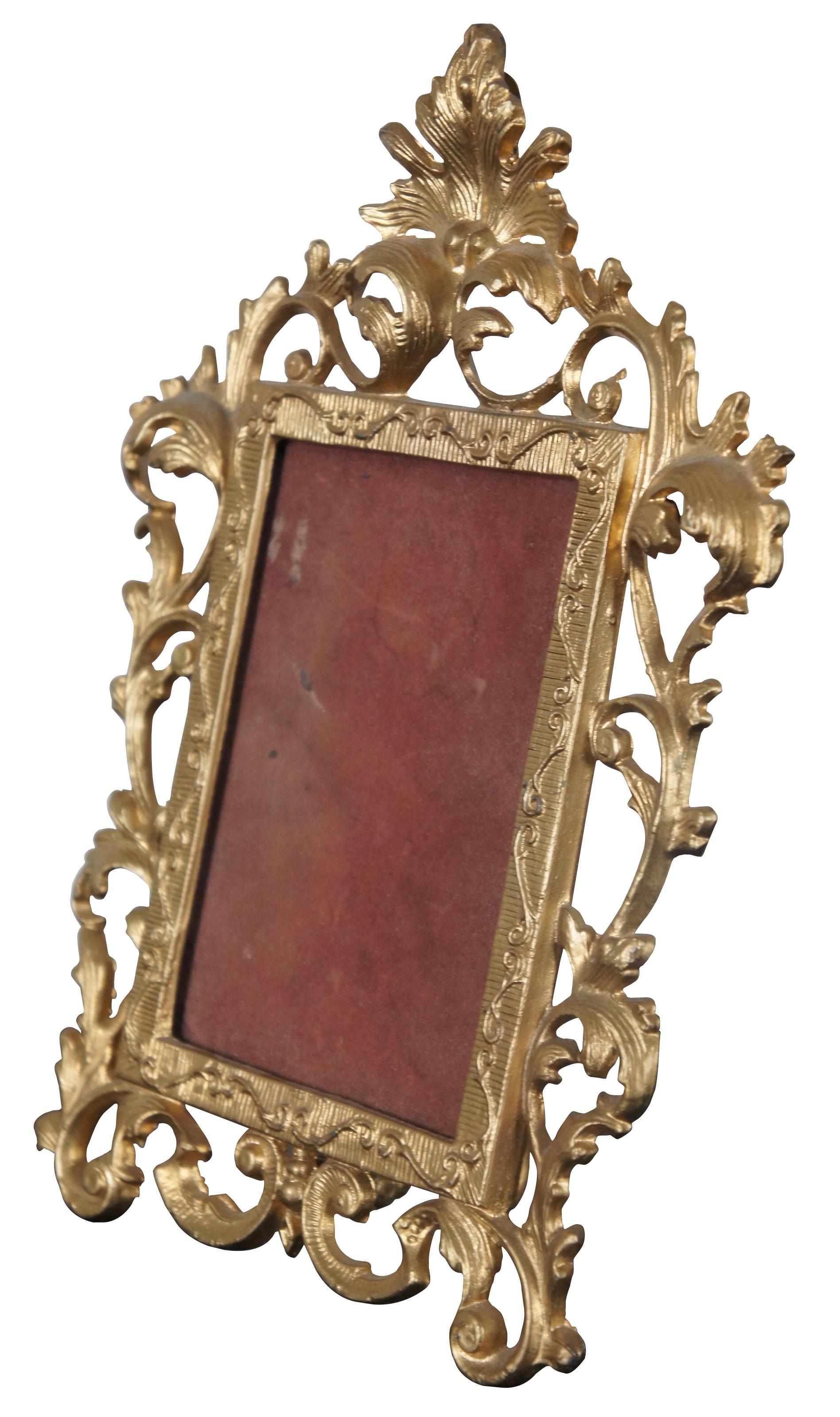 Antique gold painted cast iron picture or mirror frame styled with swirling Baroque leaves.

Measures: 8.5” x 3.75” x 11.75” / Opening - 4” x 6” (Width x Depth x Height).