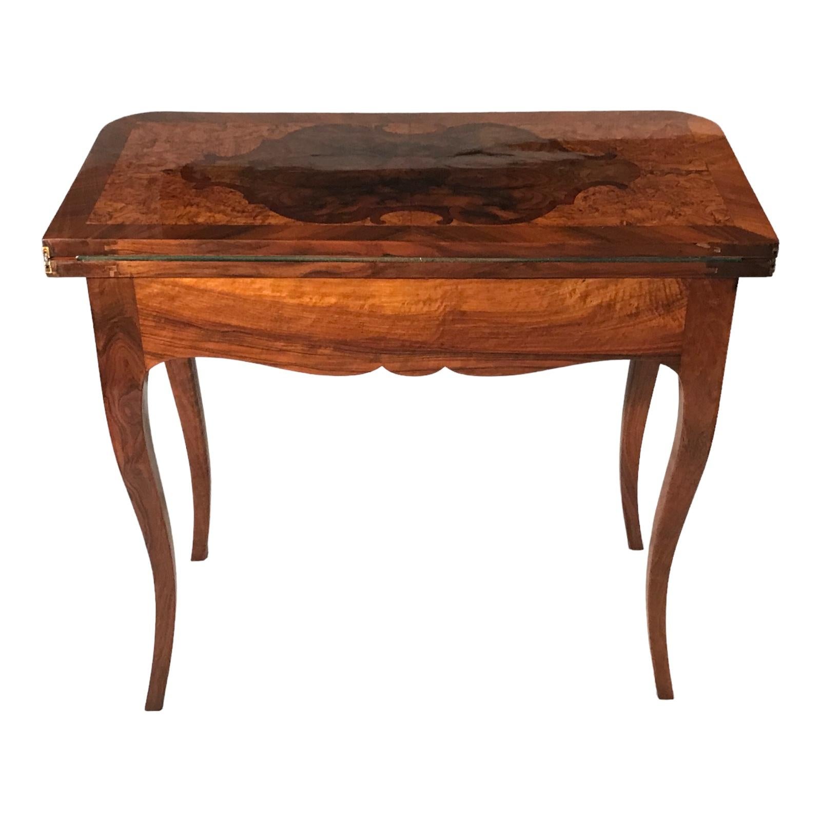 Dieser außergewöhnliche barocke Spieltisch stammt aus Süddeutschland und wird auf ca. 1770 datiert. Das atemberaubende Walnussfurnier trägt zu seiner optischen Attraktivität bei. Die Tischplatte ist mit komplizierten Mustern aus Ahorn- und