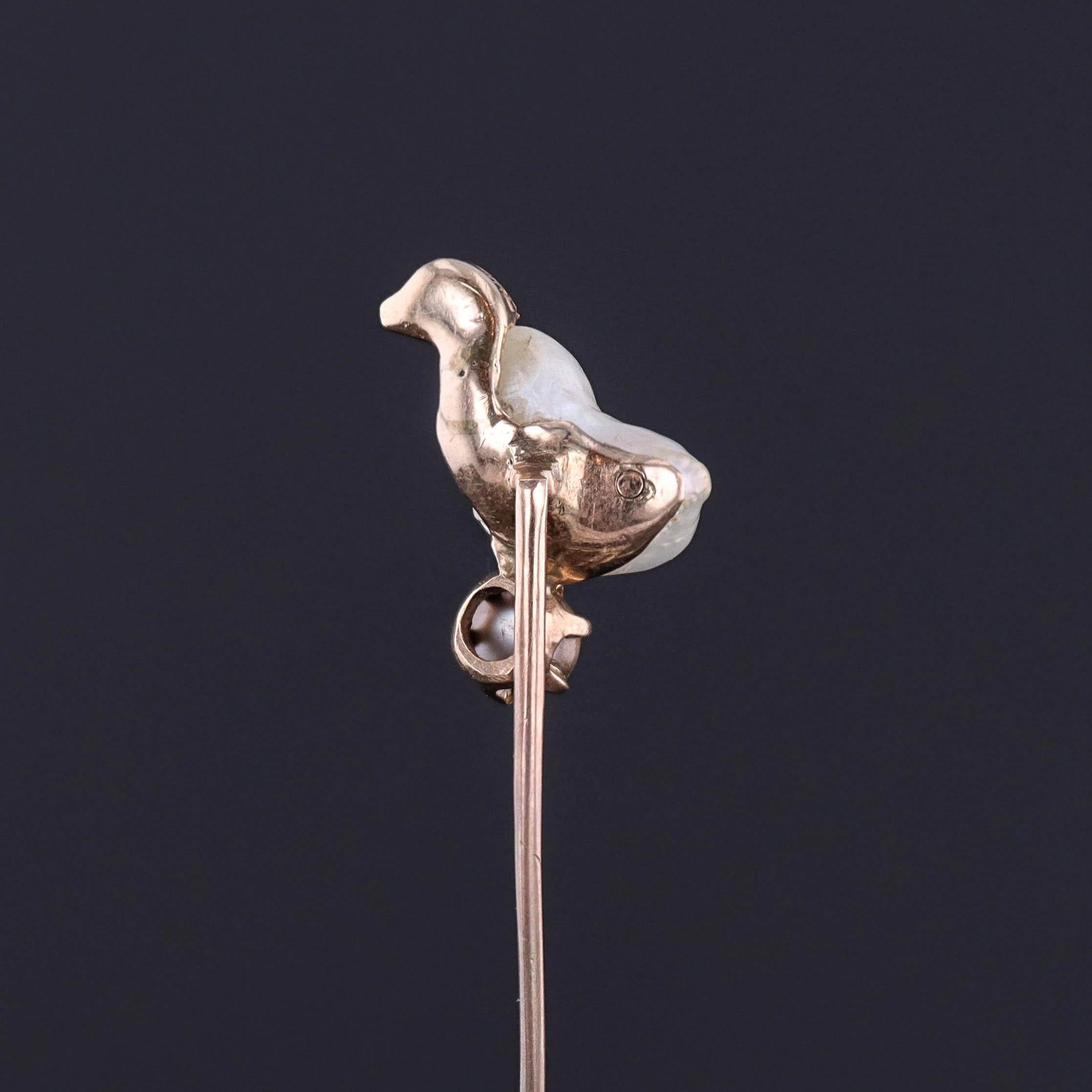 A 10k gold stickpin from the late Victorian era (circa 1890-1900) featuring a baroque pearl chick with a diamond eye perched atop a Tahitian south sea silver pearl.

The pin head measures 0.7 inches by 0.5 inches wide with the entire pin measuring