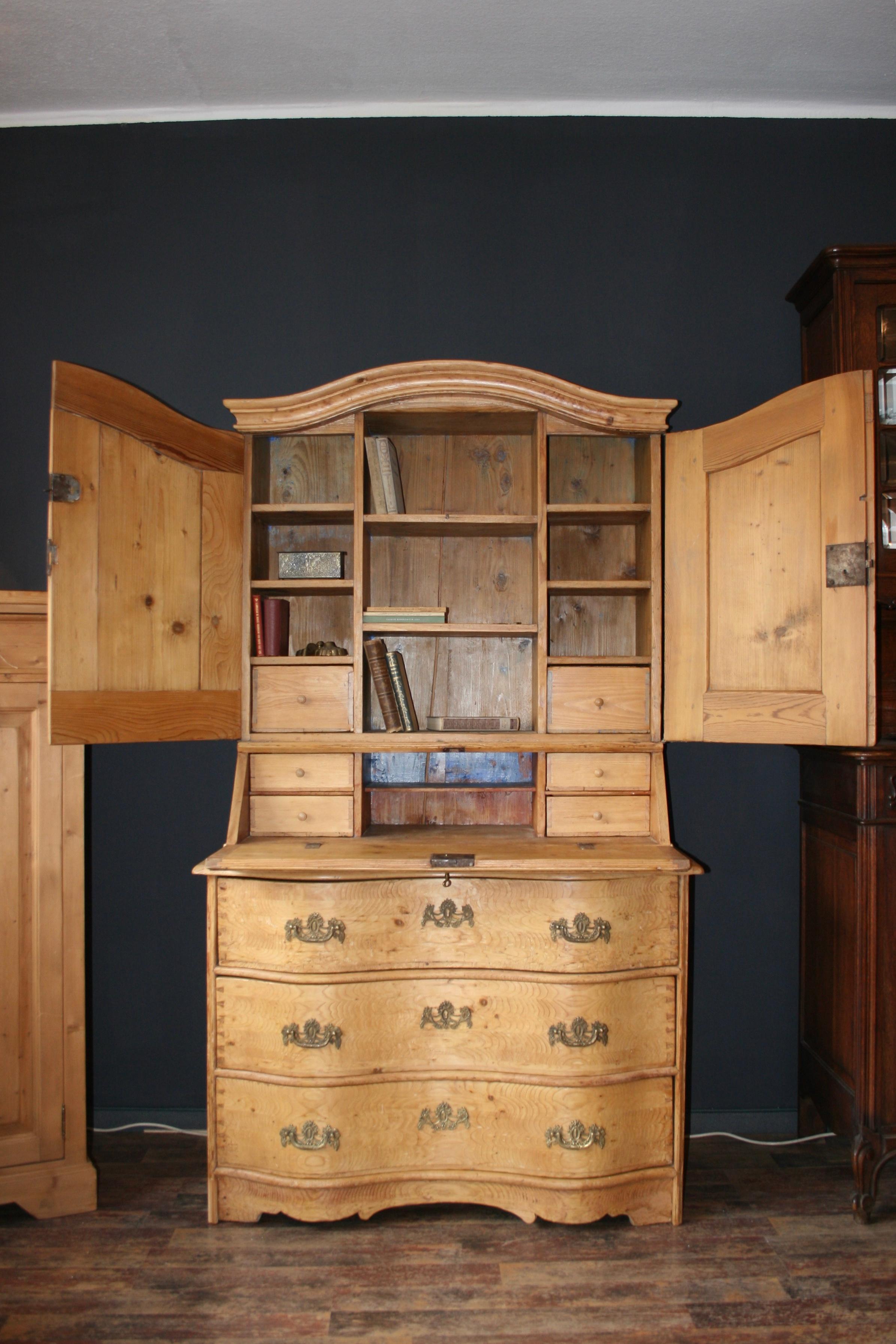 Antique baroque secretaire made of pine wood, 18th century, circa 1750.
The secretary consists of a top and a bottom. The curved lower part (like a Baroque chest of drawers) has 3 drawers, on whose fronts one can recognize the dovetail connections,