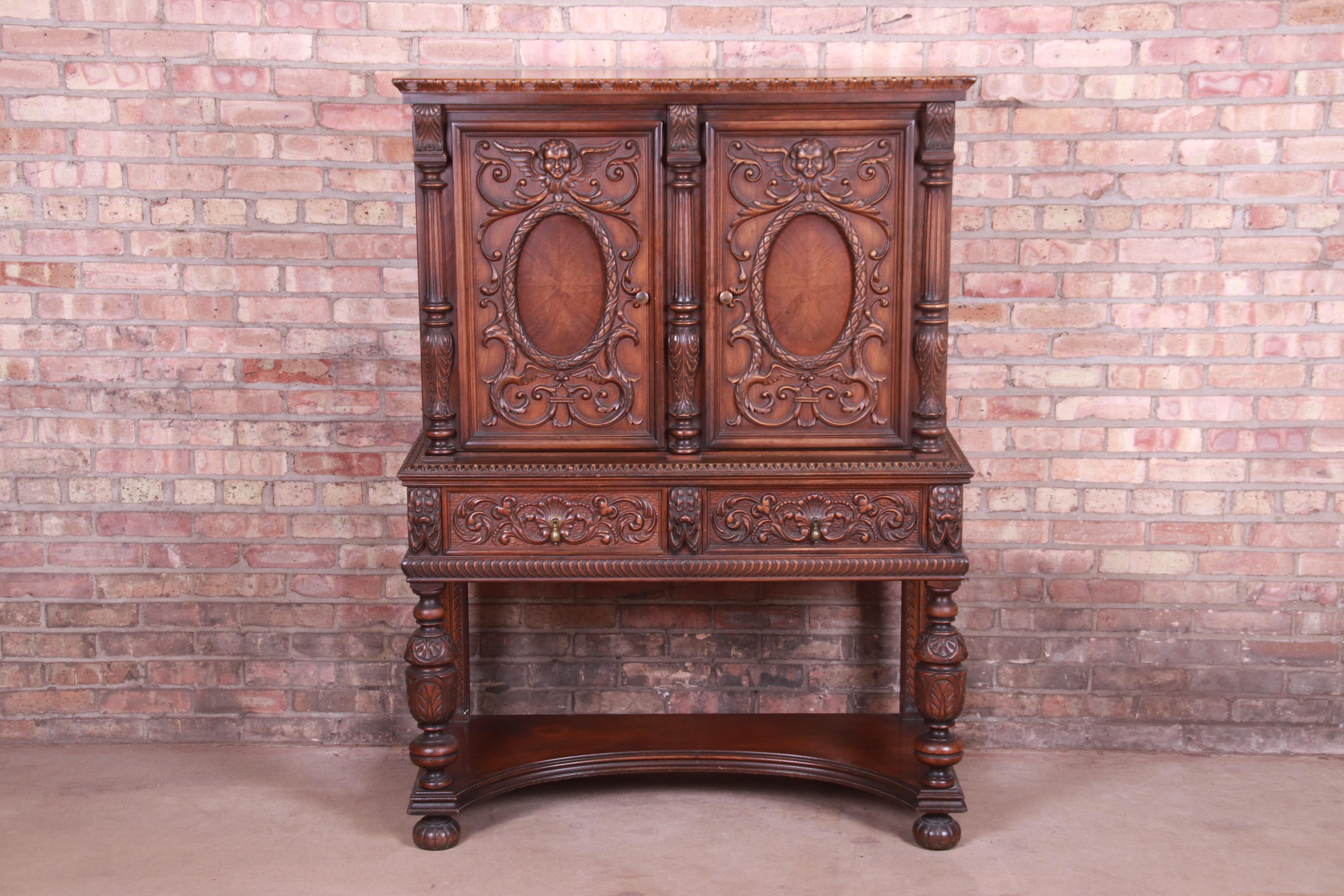 A gorgeous antique Baroque Renaissance carved walnut sideboard hutch, bar cabinet, or bookcase,

Early 20th century

Walnut, with ornate carvings of faces, birds, and foliage. Original brass hardware.

Measures: 44
