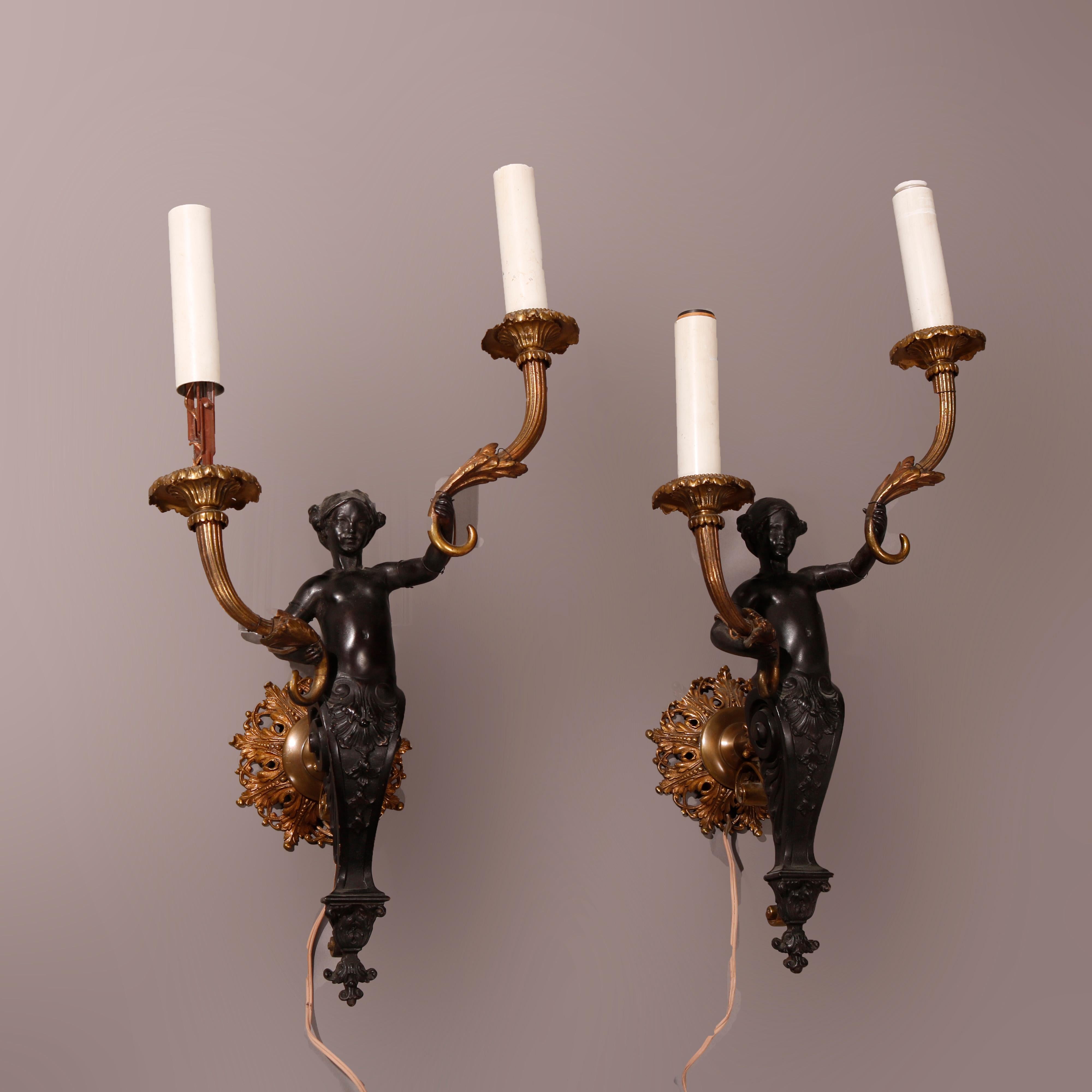 An antique pair of Baroque style figural electrified wall sconces offer cast bronze construction with central ebonized female caryatids holding foliate form arms terminating in candle lights, c1900

Measures - 23.5''H X 11.5''W X 8.75''D.