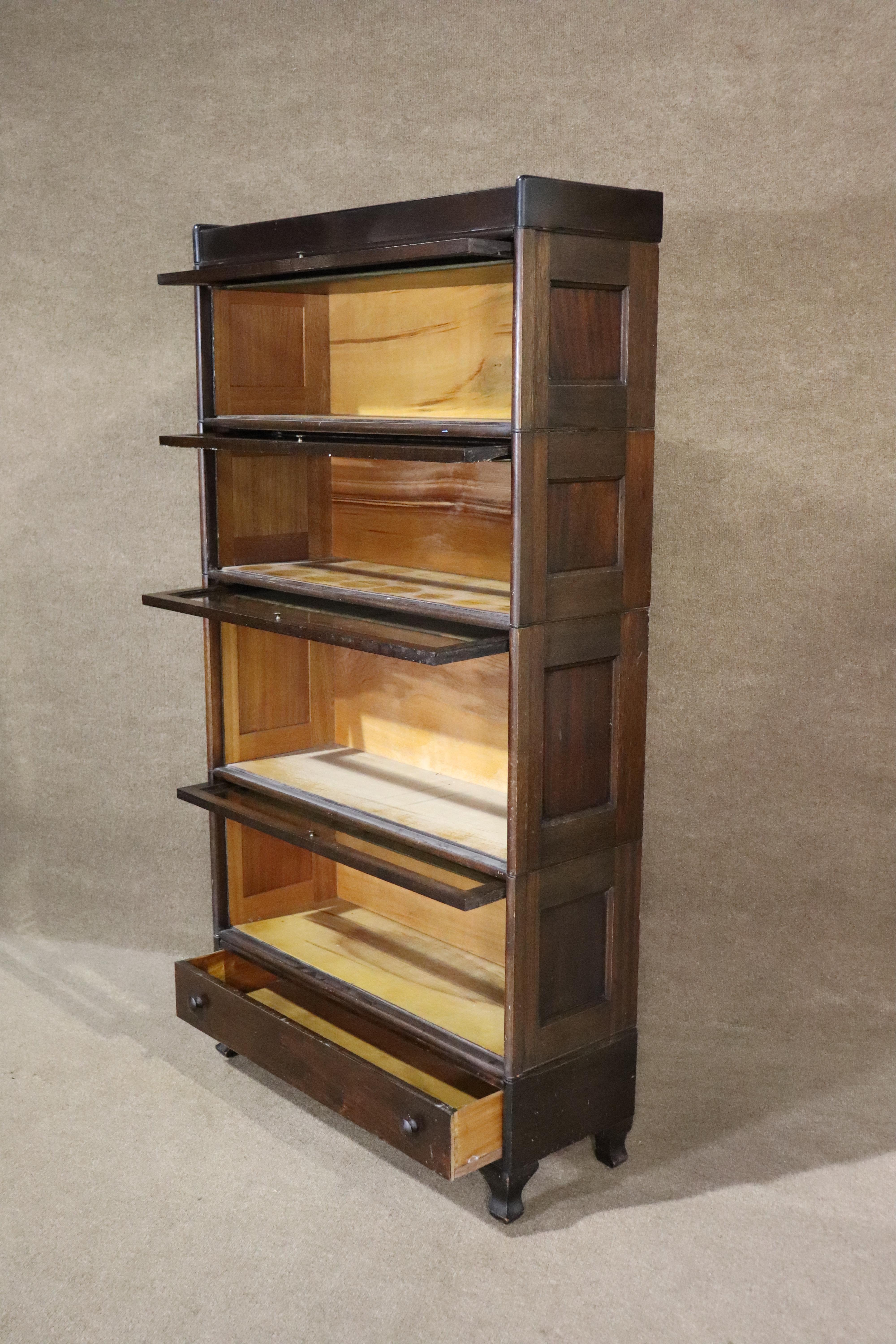 Five piece stacking bookcase with four glass covered units and bottom drawer storage. This unit was taken from a law office and used by the 