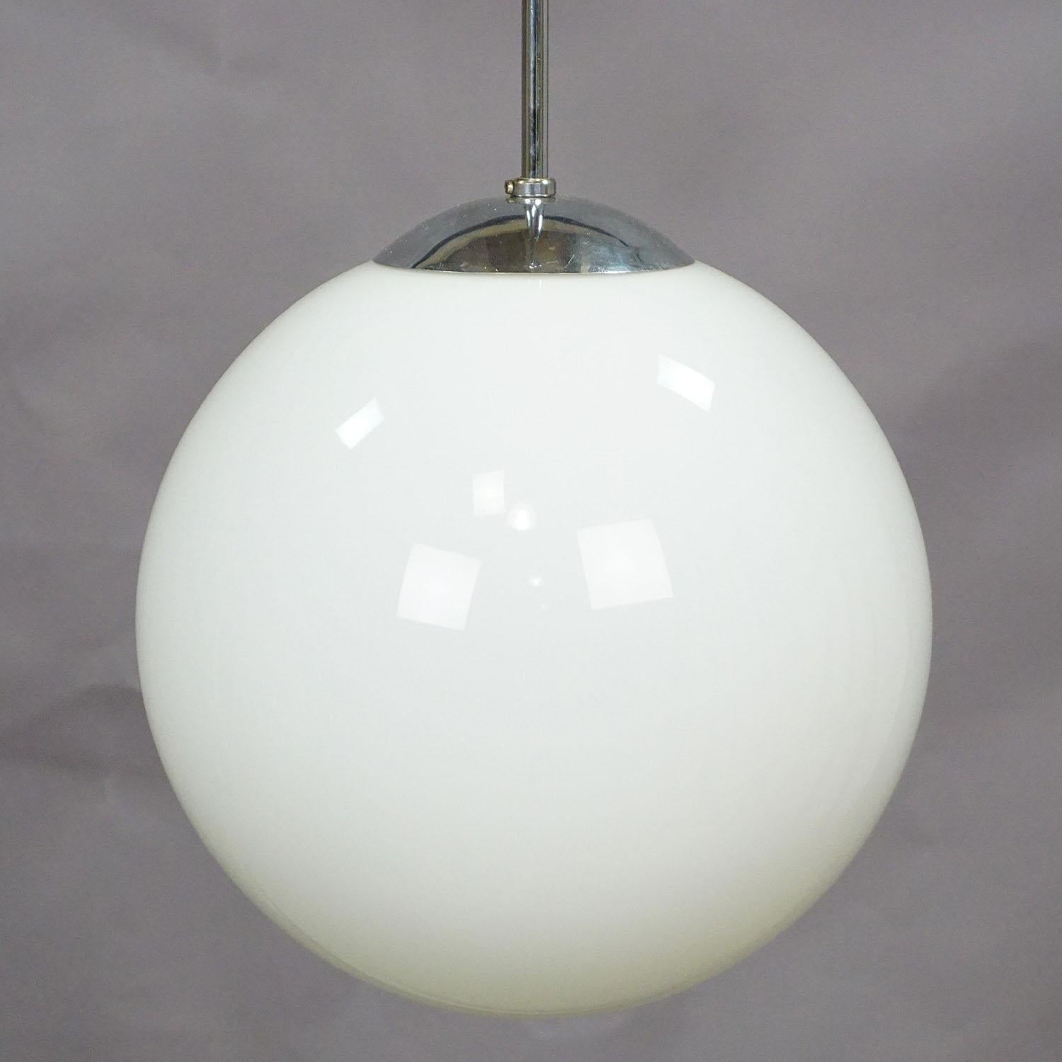 An antique Bauhaus style pendant lamp with a large white opaline glass shade and chromium plated metal suspension. Cabling renewed, working order. With international E27 base lamp holder.

Measures: Height 35.43