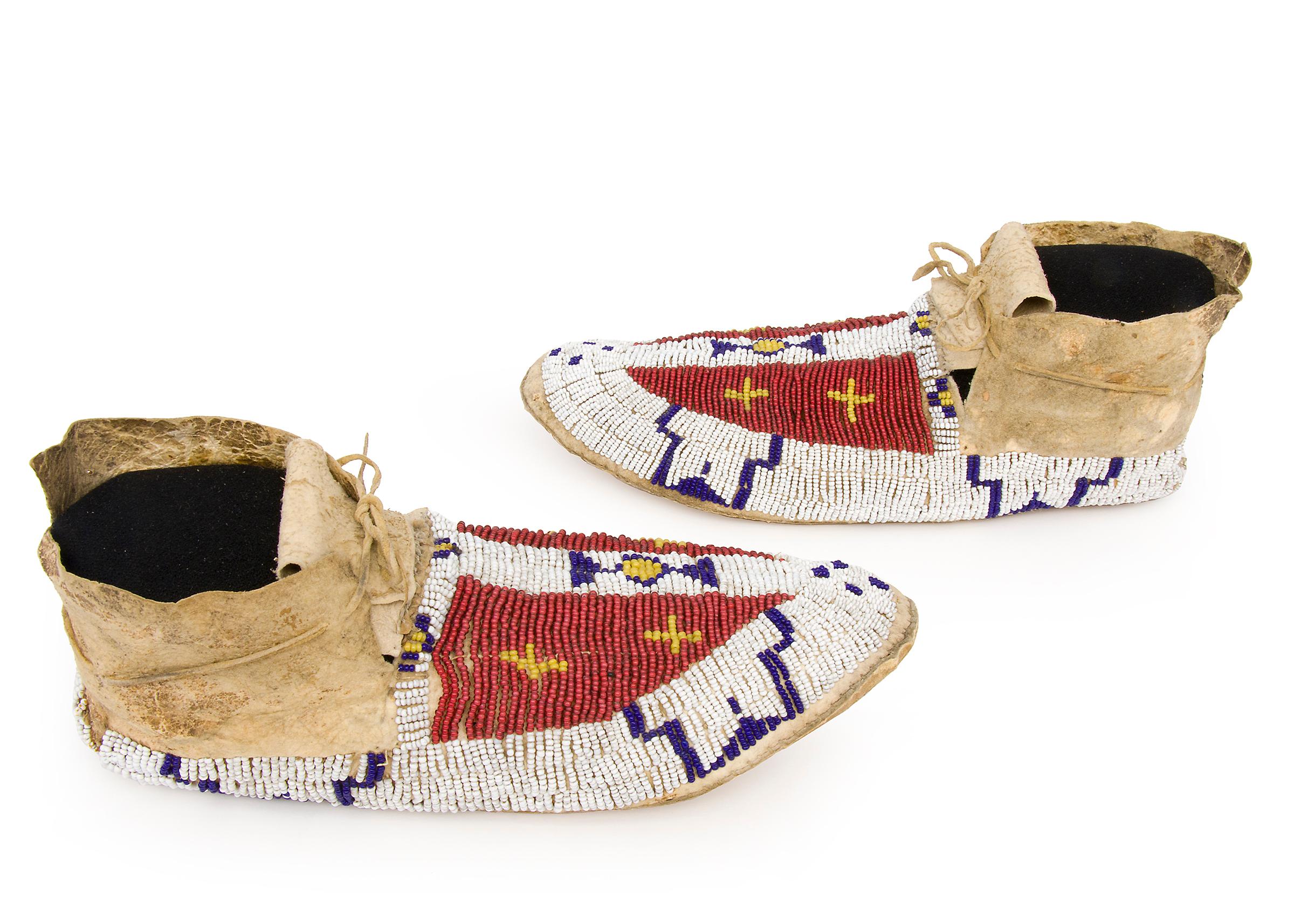 19th century Native American Beaded Moccasins, Cheyenne (Plains Indian), circa 1880s. Native tanned hide with glass trade beads in red, white, yellow and blue. Buffalo Track design in white-heart red with yellow crosses.
The Cheyenne originally