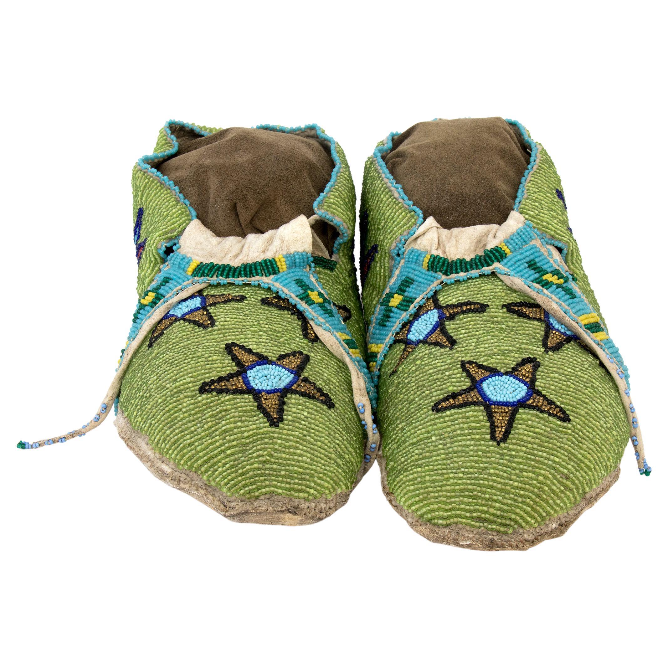 Vintage 19th century Native American Beaded Moccasins, Cree (Plains Indian), circa 1890. Native tanned hide with glass trade beads in green, blue, yellow, red, and white, with pictorial elements including star and cactus flower motifs. Custom