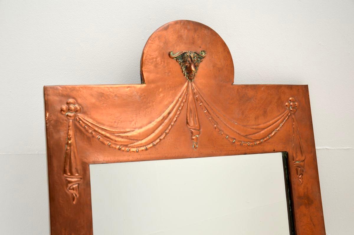 Precioso espejo antiguo de cobre batido, fabricado en Inglaterra, que data aproximadamente del periodo 1890-1910.

La calidad es asombrosa, con un trabajo de metal fundido muy fino que representa una cabeza de carnero en la parte superior central.