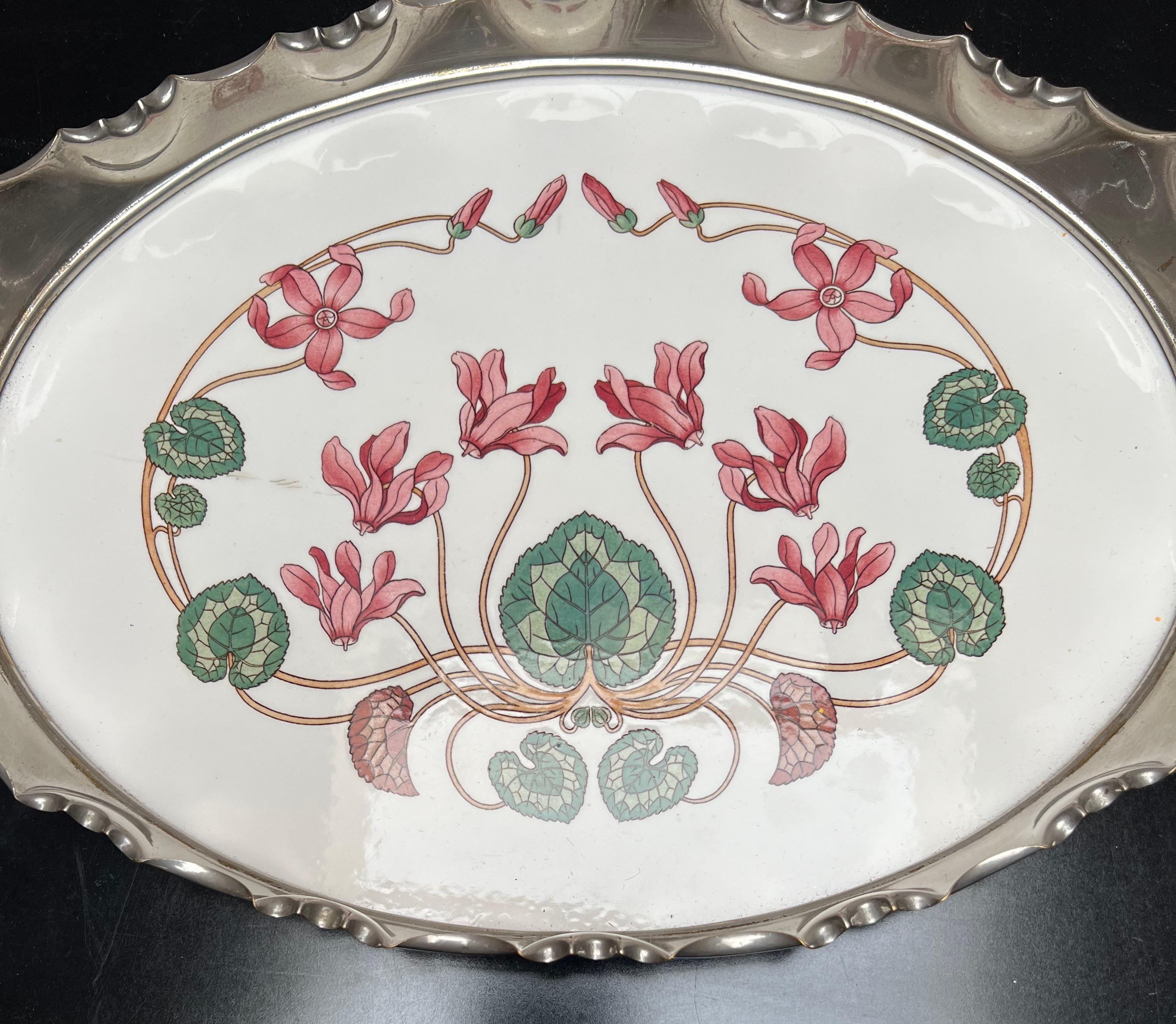 Rare and beautifully hand painted porcelain tile in chrome metal frame serving tray.

This beautiful quality, oval shaped tile serving tray is an absolute joy to own and to look at. It is a smaller than average specimen and apart from some minor