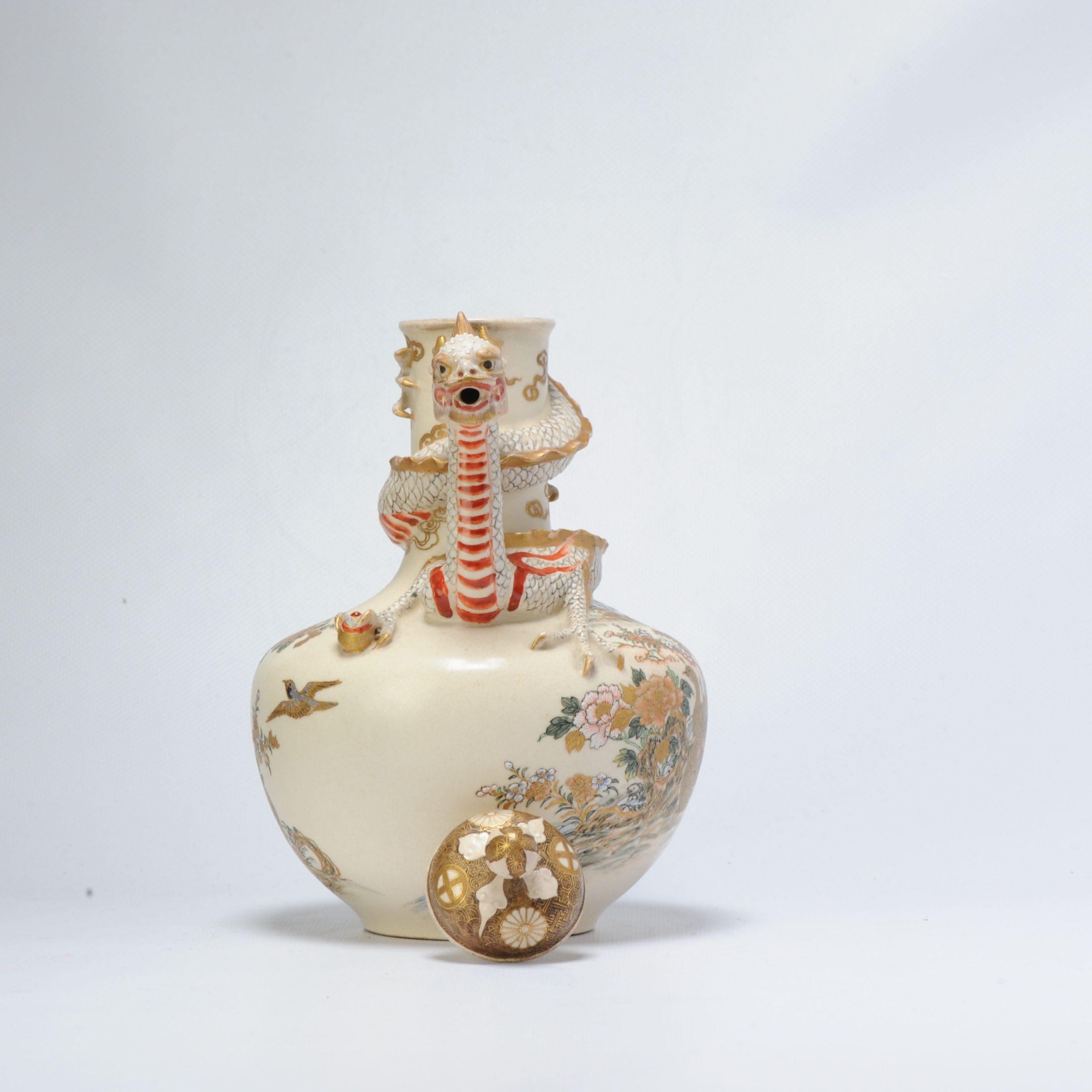 A japanese satsuma earthenware ewer and cover, of baluster shape, moulded with a dragon head spout and handle, the body painted with flowers, birds and 2 peacocks. marked:

Additional information:
Material: Porcelain & Pottery
Region of Origin:
