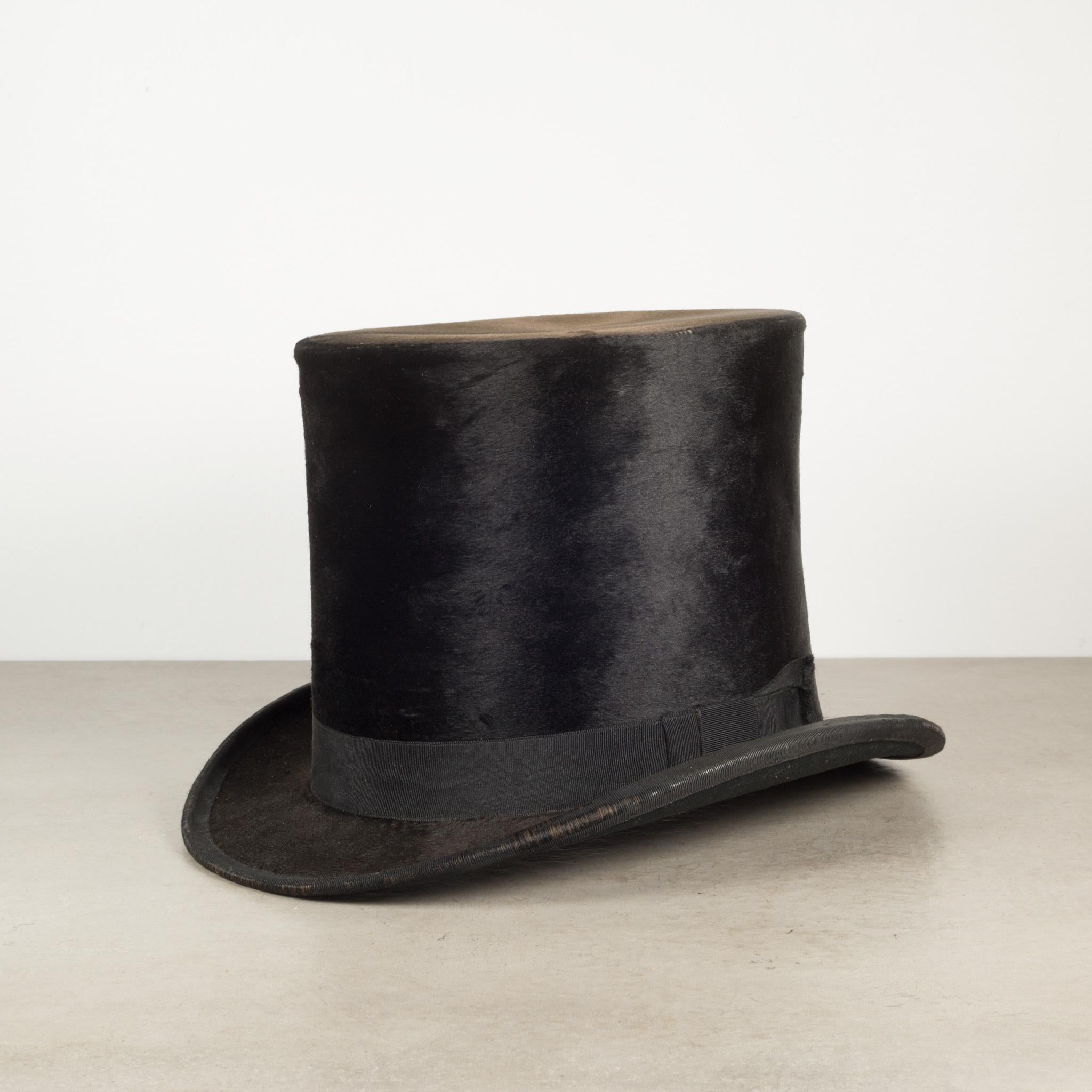 About

This is an original America Fine Make Co. beaver skin top hat with its original leather box. The top hat is covered in beaver skin which is in good condition, showing some slight wear. The leather hat box has a silver latch and some slight
