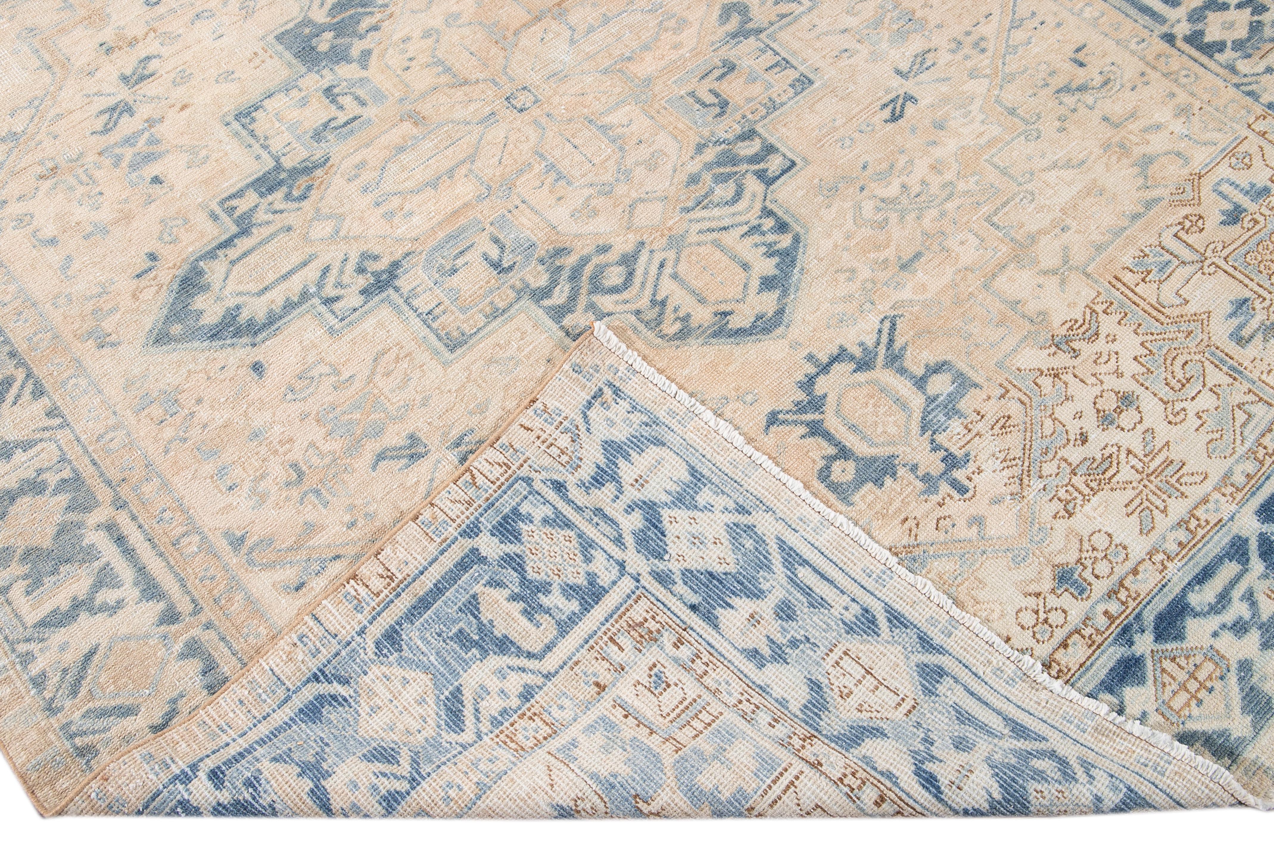 Beautiful antique Persian Heriz hand-knotted wool rug with a beige field. This Heriz rug has a blue frame and accents in an all-over gorgeous geometric medallion floral design.

This rug measures: 7'2 x 9'1