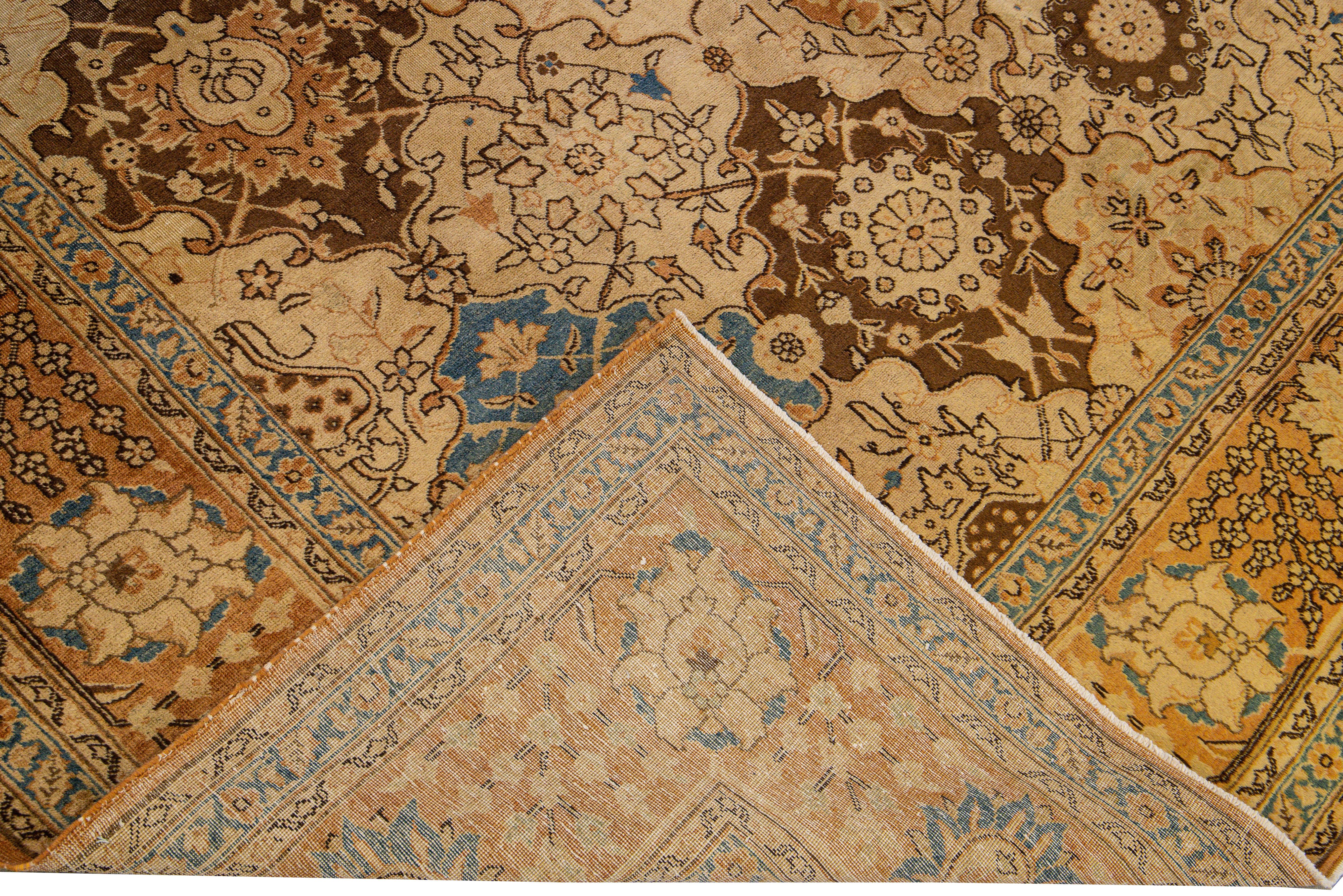 Beautiful Antique  Persian Tabriz hand-knotted wool rug with a beige field. This piece has blue and brown accents featuring an all-over multi-medallion floral pattern design. 
This rug measures: 8' x 10'8