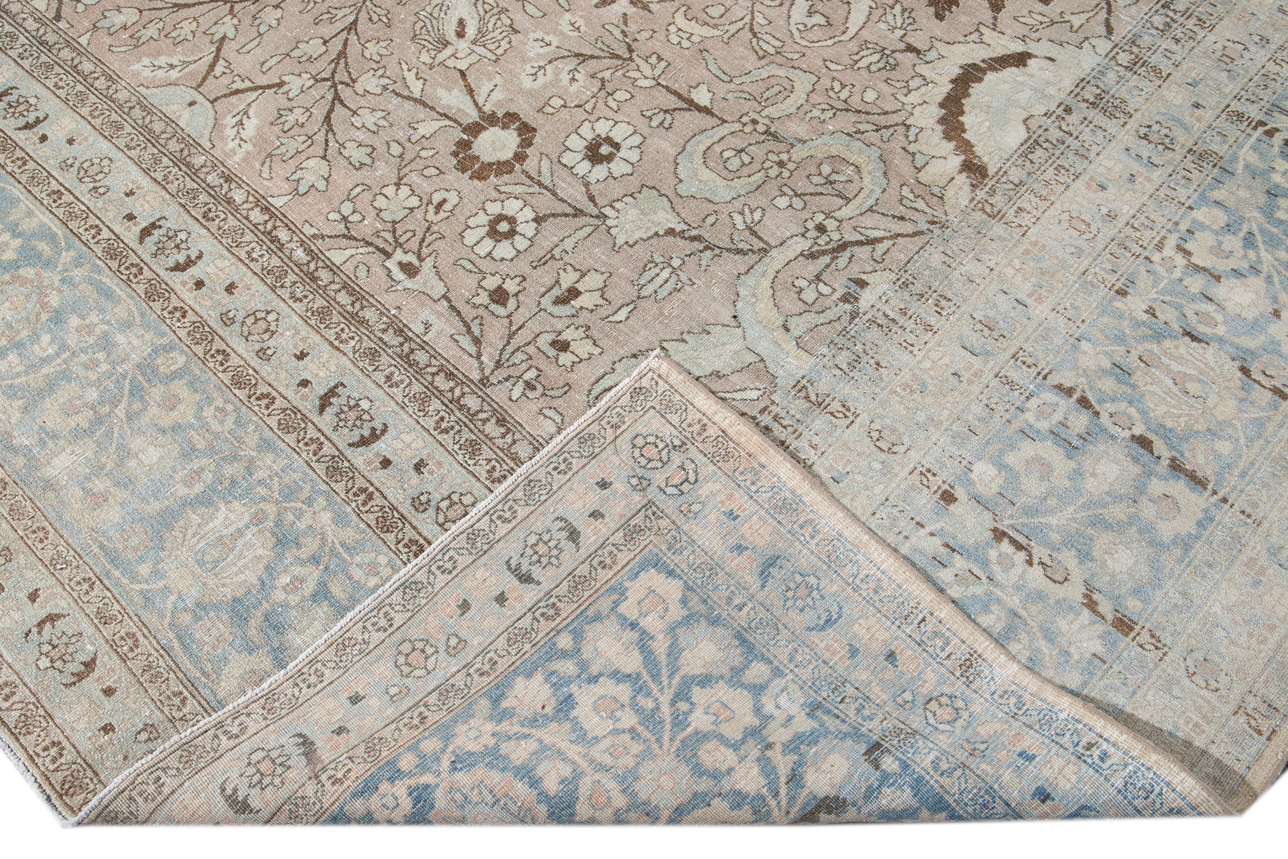 Beautiful antique Tabriz hand-knotted wool rug with a beige field. This rug has a blue frame and brown and ivory accents in a gorgeous all-over shabby chic floral design.

This rug measures: 10'9