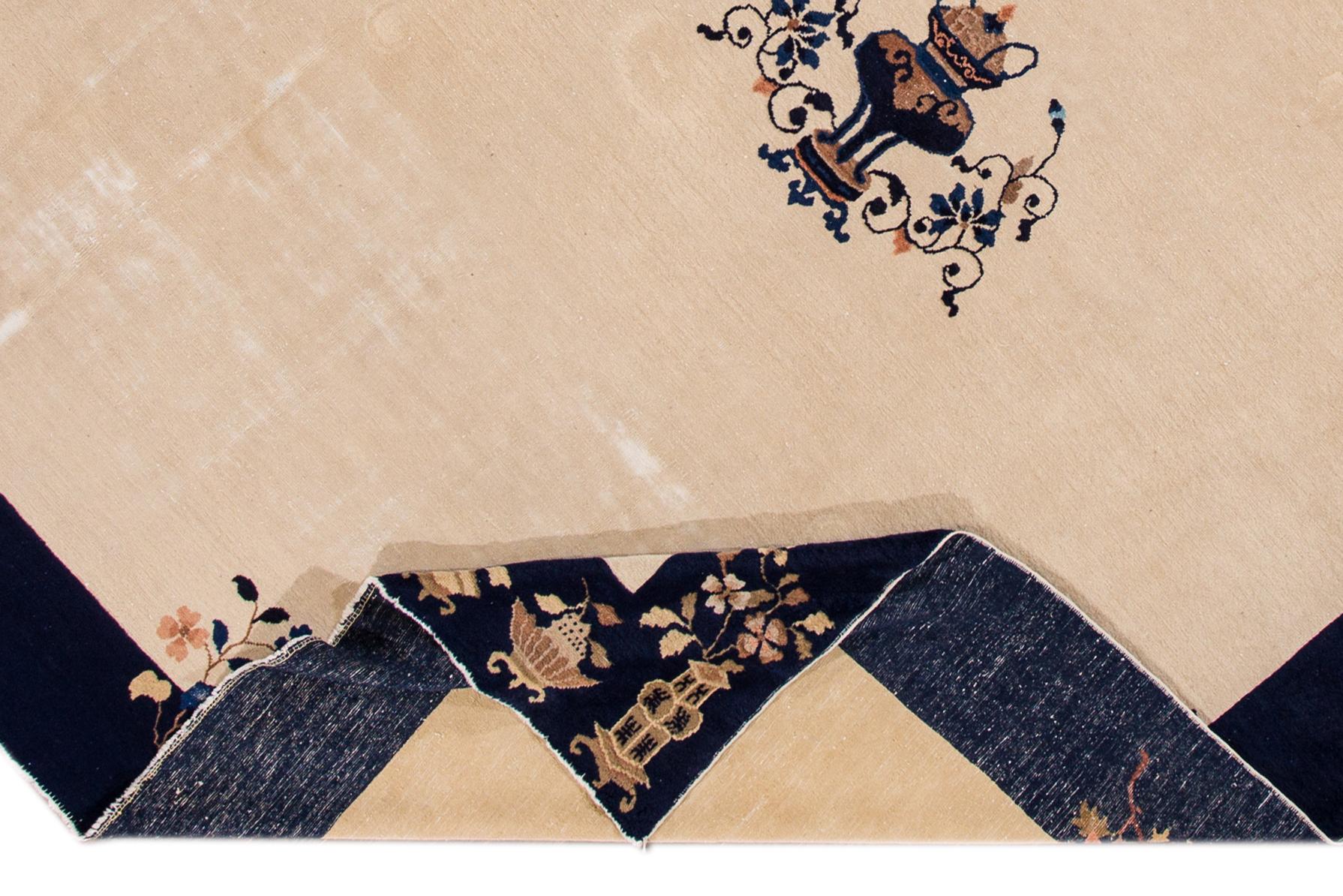 Ein schöner antiker chinesischer handgeknüpfter Wollteppich aus Peking mit einem beigen Feld. Dieser Teppich hat einen Rahmen aus blauem und mehrfarbigen Akzenten im chinesischen Design. 

Dieser Teppich misst 9'0