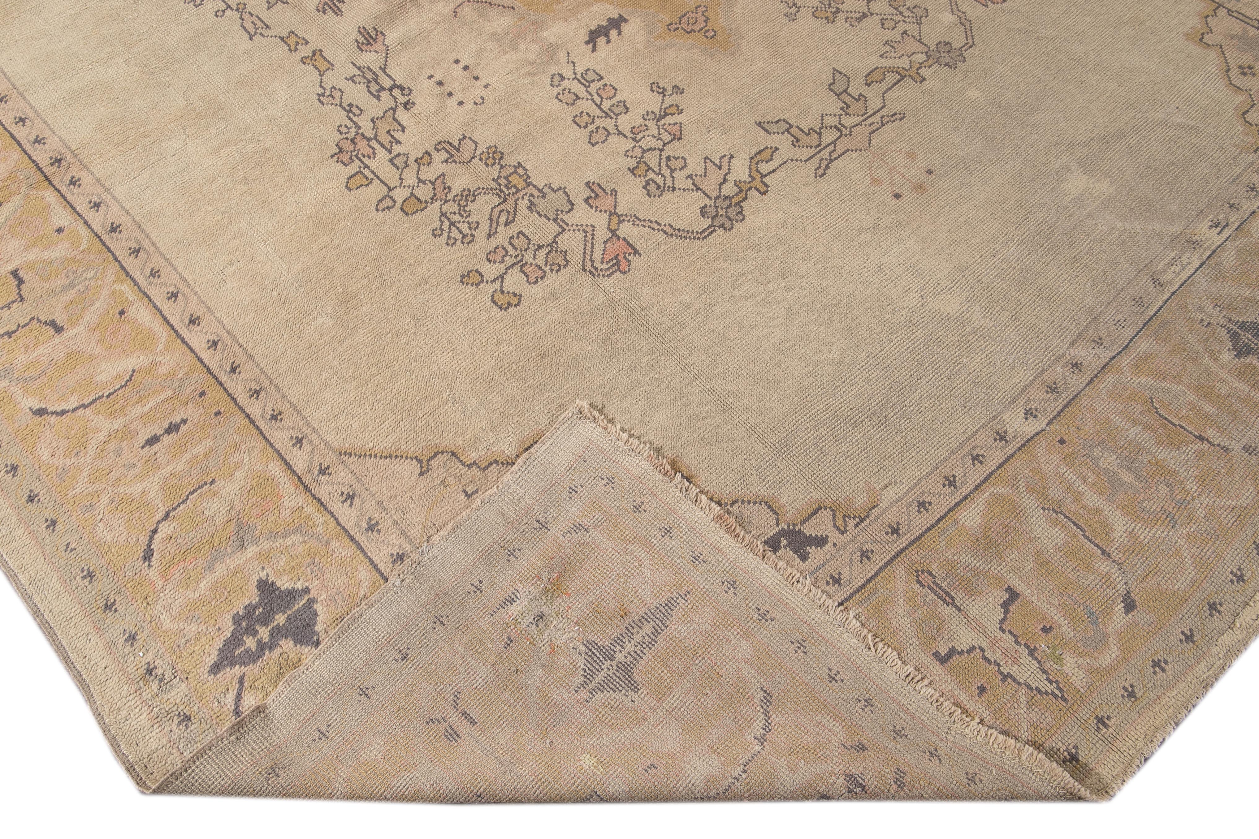 Beautiful antique Turkish Oushak hand knotted wool rug with the beige field. This Oushak rug has a goldenrod frame peach, pink, and yellow accents in a gorgeous all-over center medallion floral design.

This rug measures: 10'2