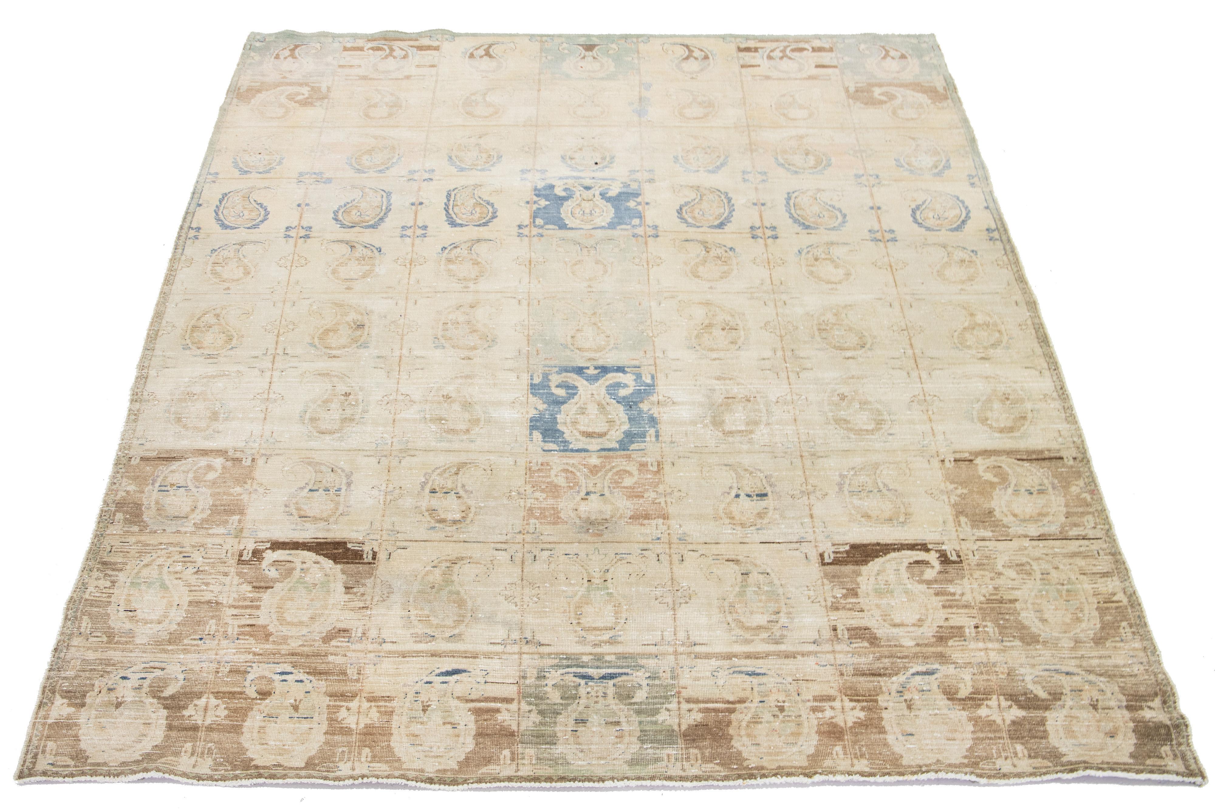 This beautifully handcrafted Persian Tabriz wool rug displays a classic all-over Boteh pattern. The beige background features shades of blue and brown.

This rug measures  8'9