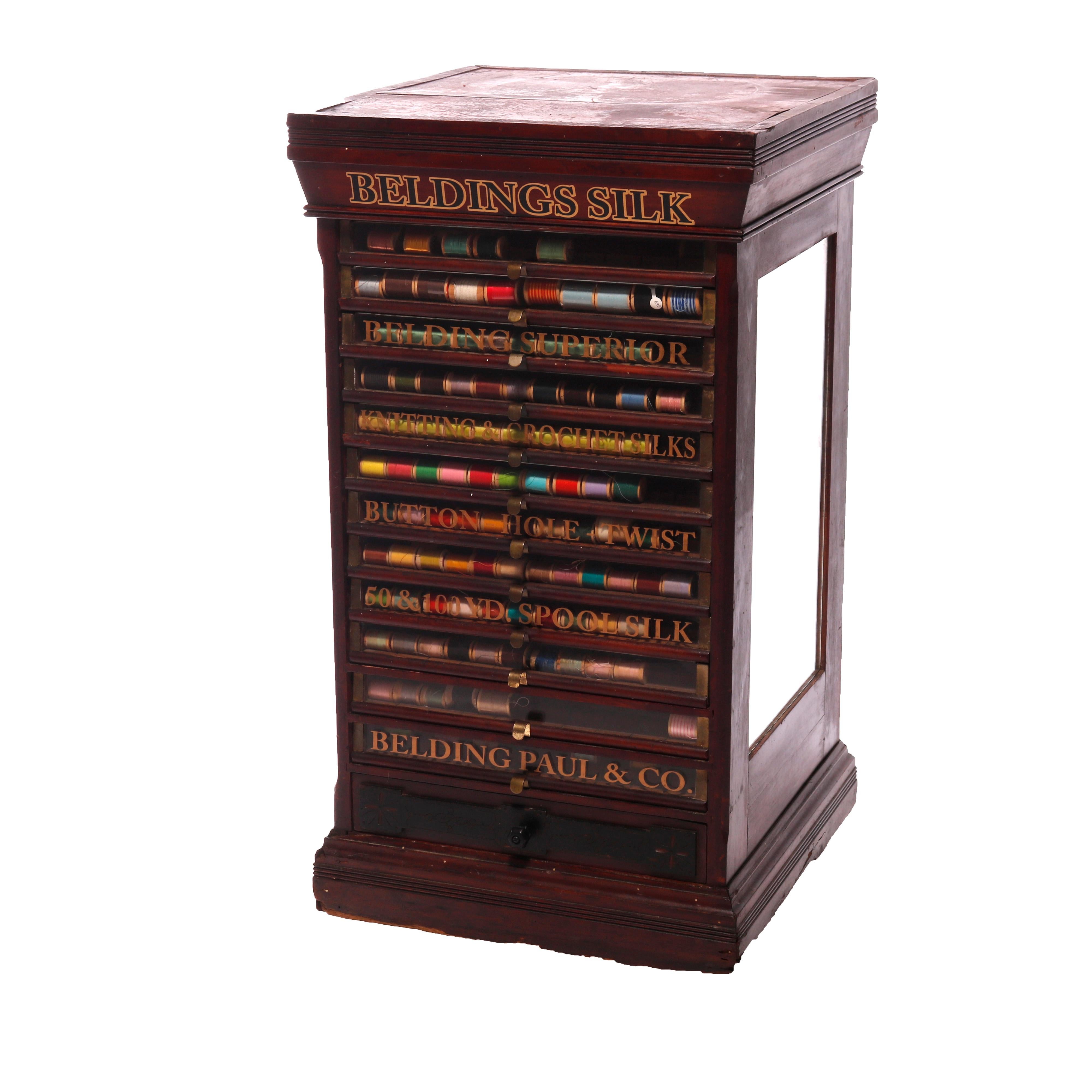 An antique Beldings Silk country store advertising spool cabinet offers thirteen glass front pull-out shelves (drawers), some with gilt lettering, case with mirrored sides, thread collection included, c1890

Measures - 35''H x 19''W x 19.5''D.