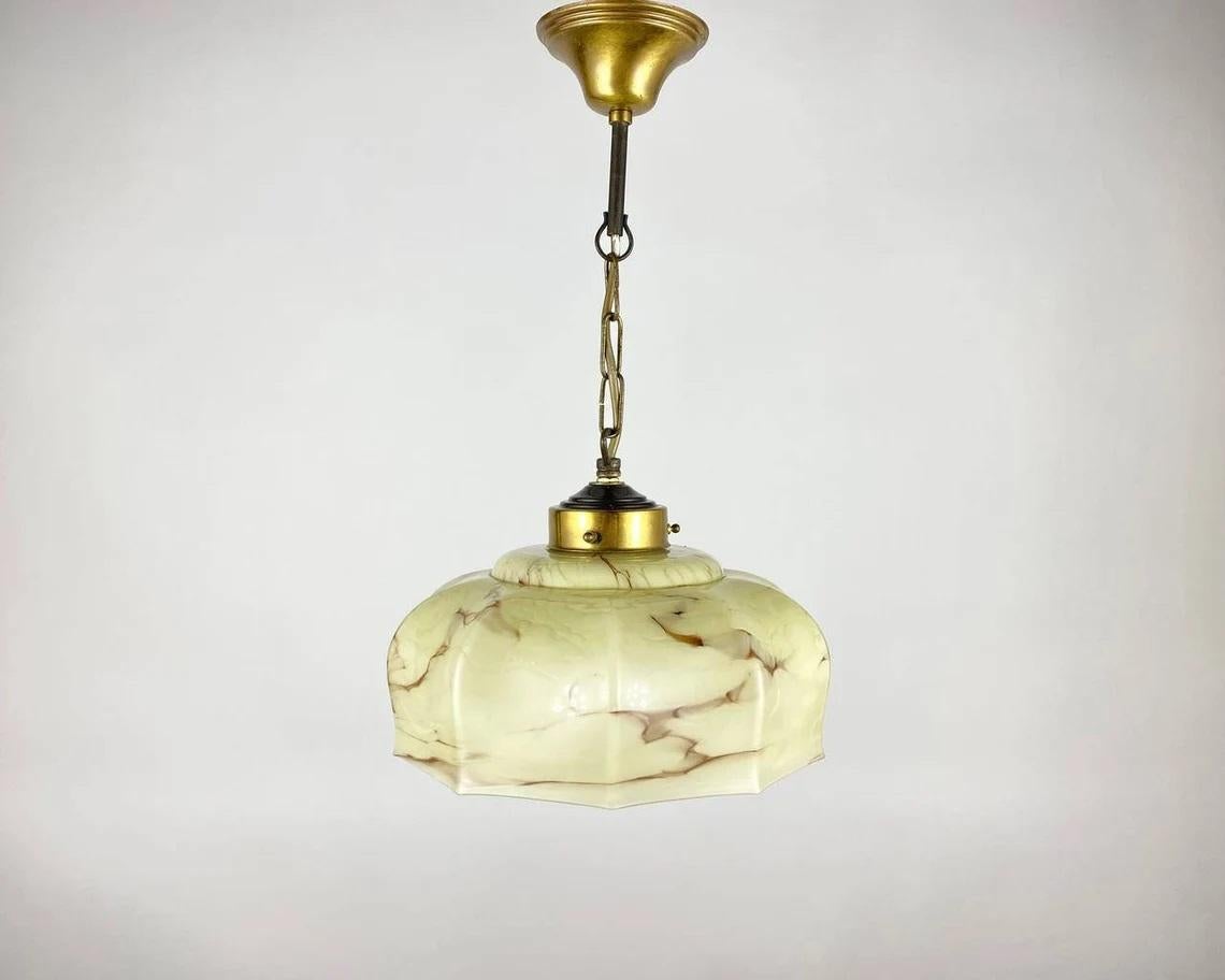 Charming vintage hanging lamp.

Hanging lamp with beautiful glass shade, decorated. Metal parts are covered with gilding. Emits diffuse light upwards and bright light downwards. Belgium.

Selected originals from the 1960s! The furniture from