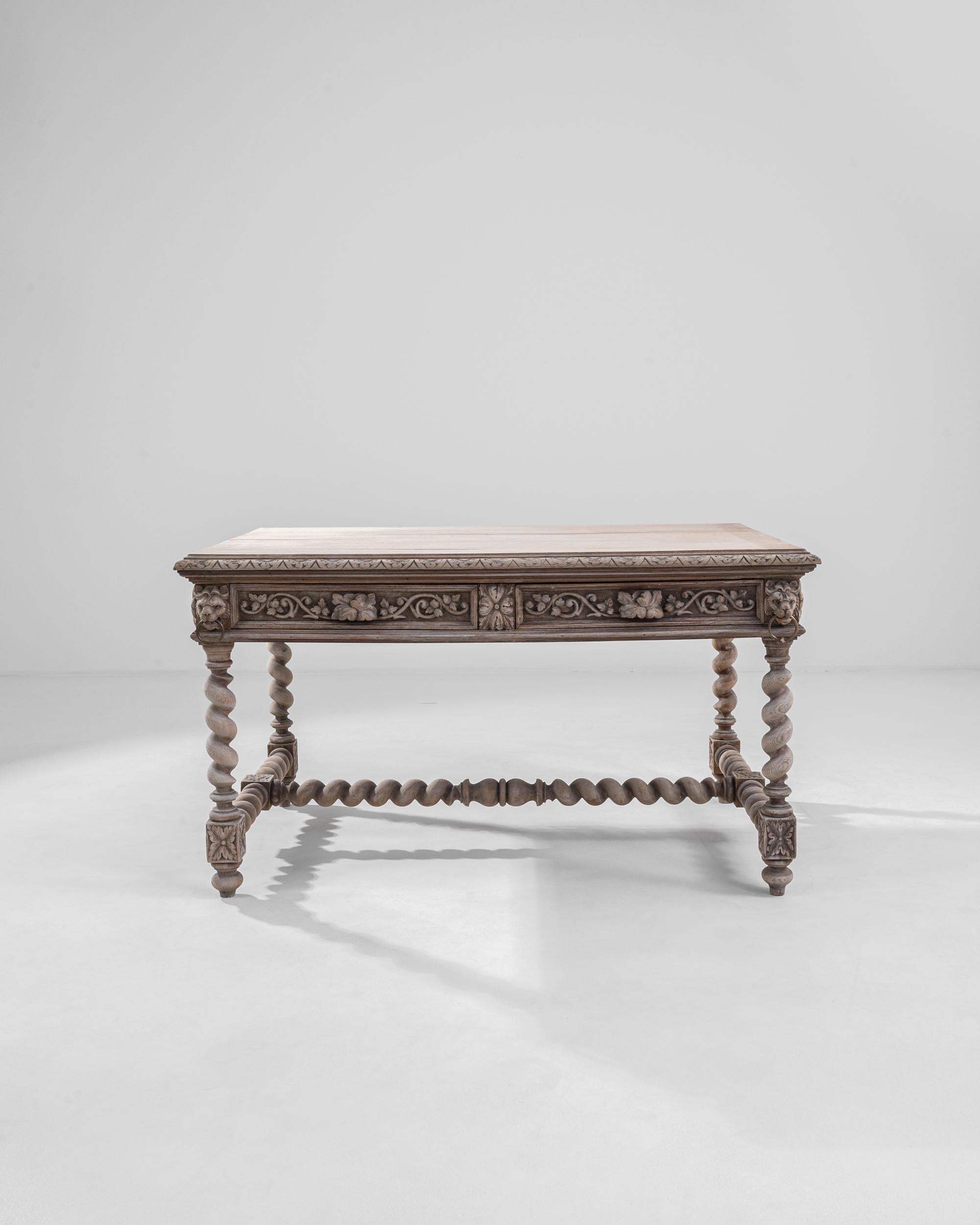 An oak dining table from Belgium circa 1900. Resonating with a distinctive Flemish Northern Baroque style, twisting legs and stretchers form the structure of this table, which shimmer in synergy with the array of scrupulously curved motifs that line