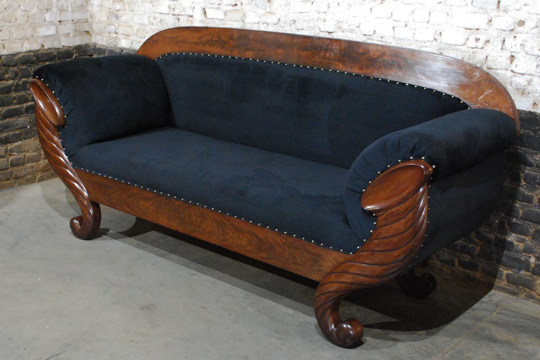 This beautiful and elegant sofa was made in Belgium, circa 1850. 
It has a solid oak base with precious mahogany veneer and impressive hand-carved legs. Both front legs have an S-curved shaped cornucopia design that relates to ancient Roman styles.