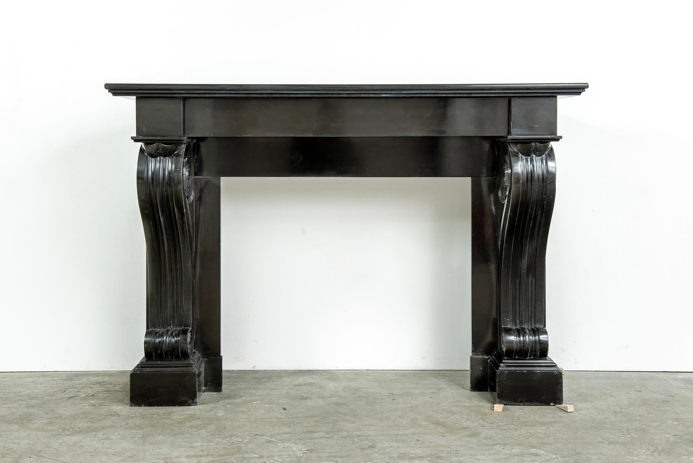 Nice French Louis Philippe style fireplace mantel in Belgian black marble.

The double rectangular topshelf sits above a straight frieze with plain endblocks on both sides above strong and heavy scrolled consoles above plain footblocks.

Overall
