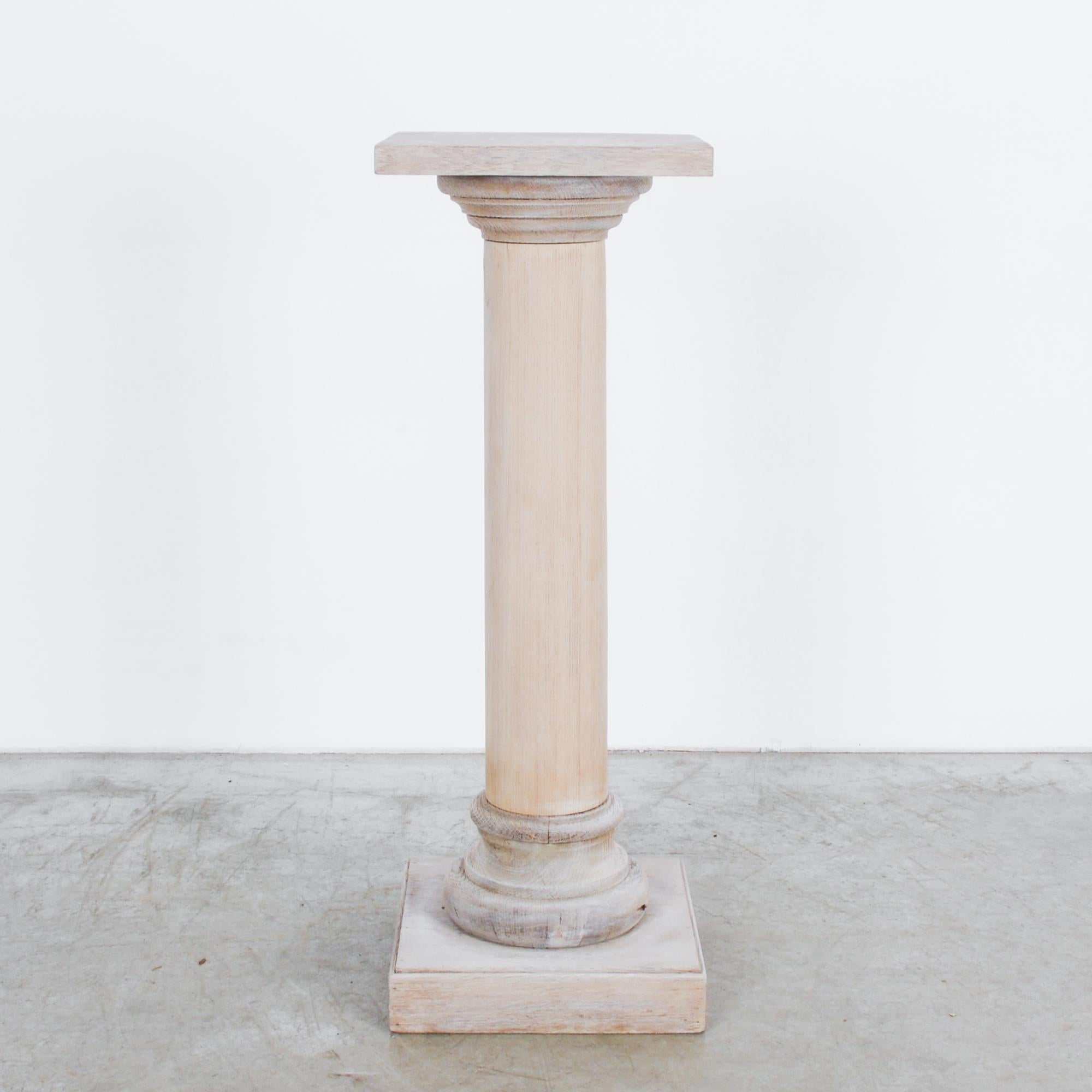 This bleached oak pedestal was made in Belgium and features a subtle neoclassical allusion with an unadorned shaft, a capital, and a base. With its smooth finish and exquisite wood grain, the pedestal will bring an understated elegance to any