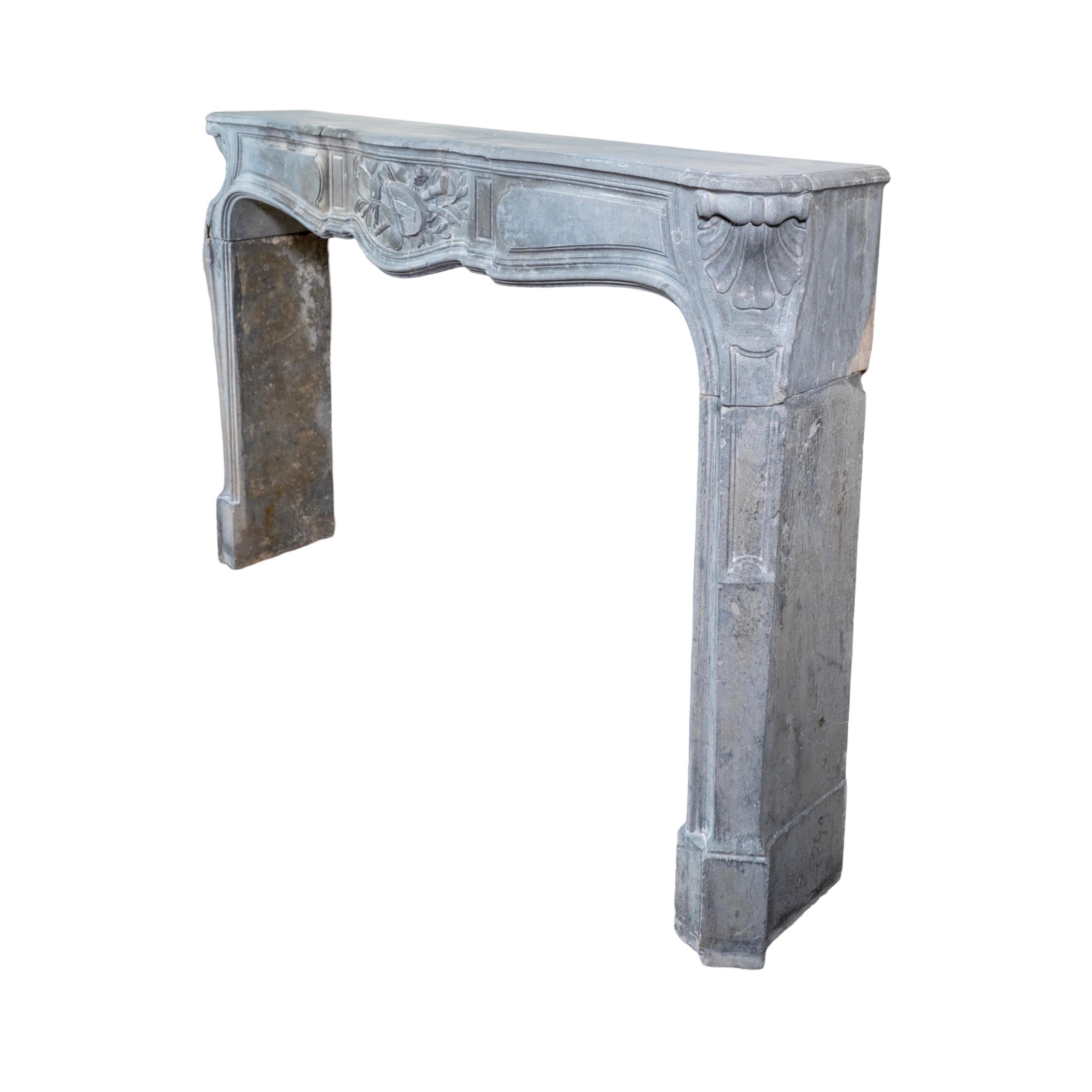 Expertly crafted in Belgium during the 18th century, our Belgian Bluestone Mantel features intricate carvings on the legs and a unique centerpiece with musical instrument motifs. Made from high-quality bluestone, this mantel adds elegance and