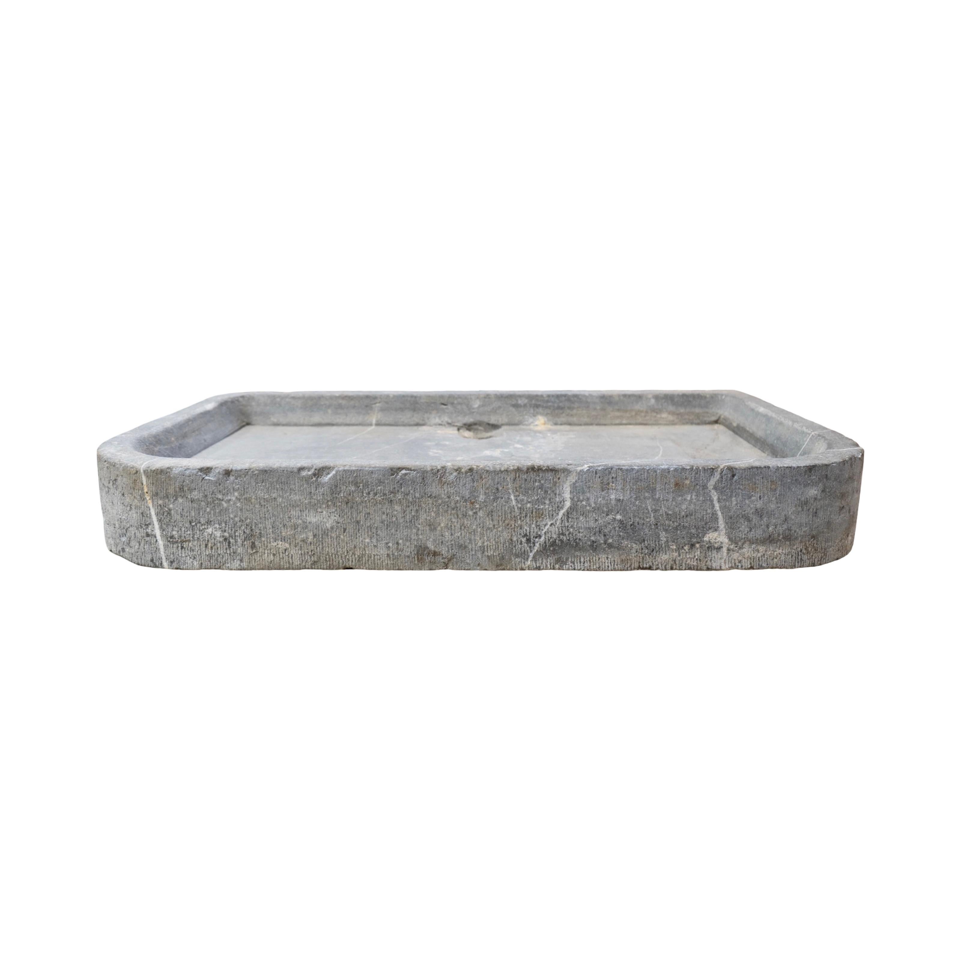 A striking 19th-century Belgian bluestone basin sink, hand-carved from a single block of dense stone with beautiful veining and natural aging throughout. The basin features a rectangular form with subtly rounded corners and a raised border