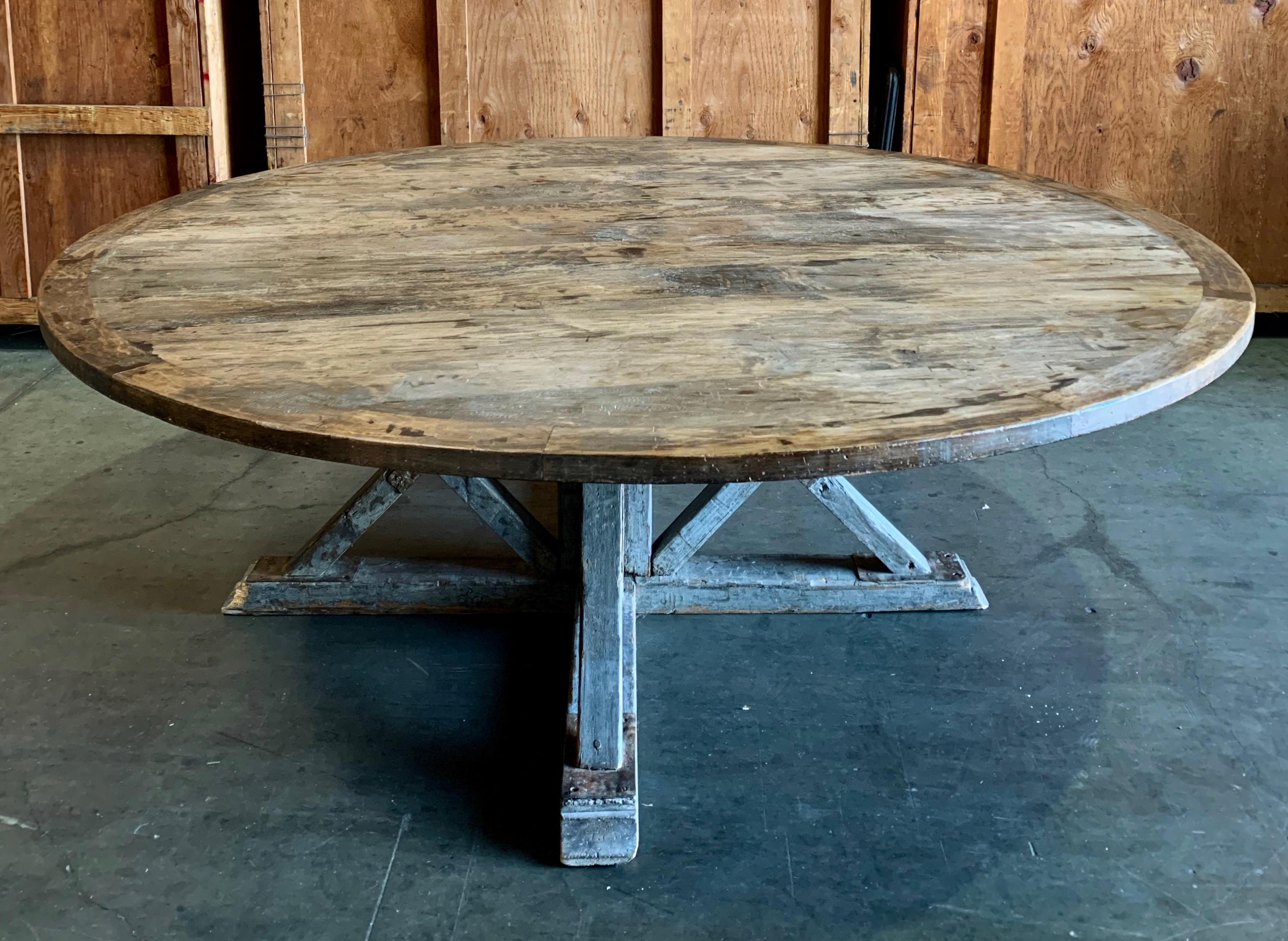 Grand, large round wooden dining table with antique base and new weathered top amply seats 8-10.
