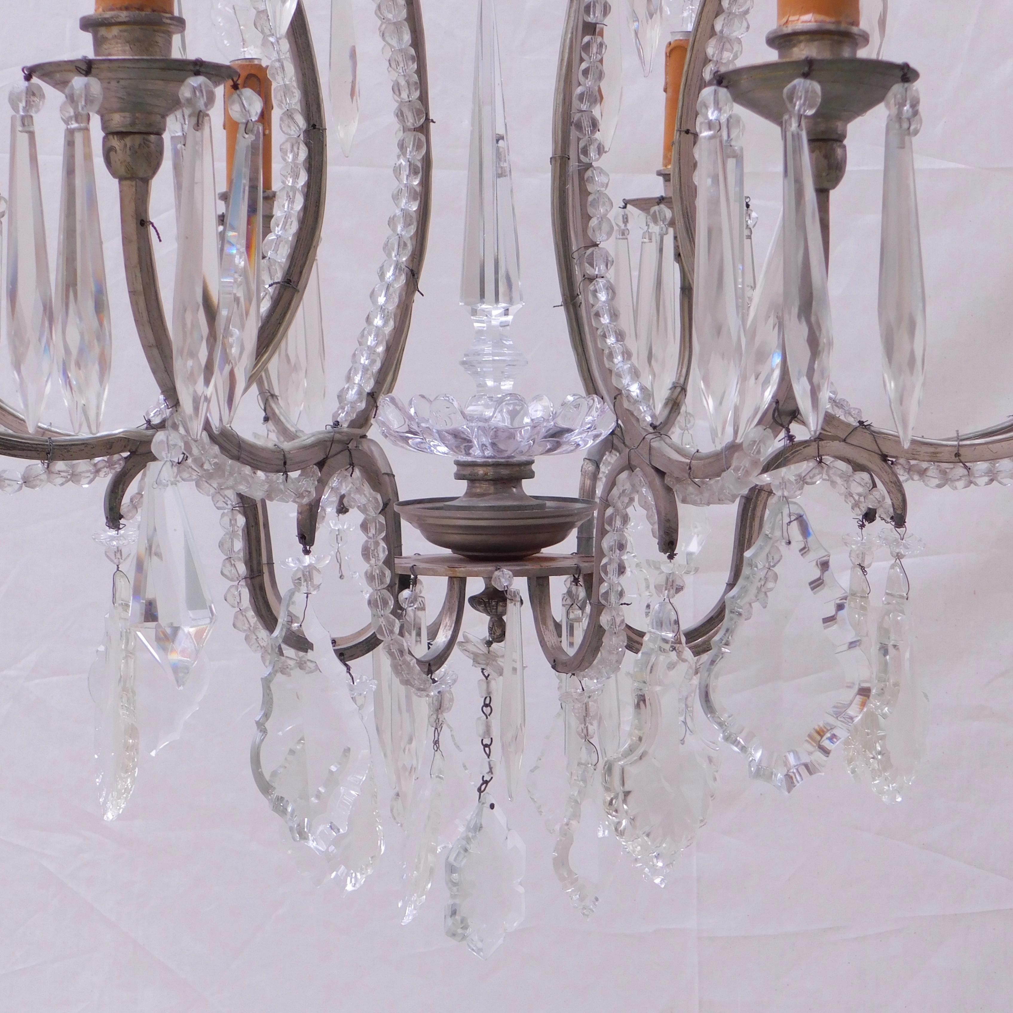 A most elegant Belgian chandelier with a silver plated metal frame beaded with prism cut glass beads and hanging crystal prisms. Wired and ready to hang.
The height listed is to the top of the ceiling cap canopy.