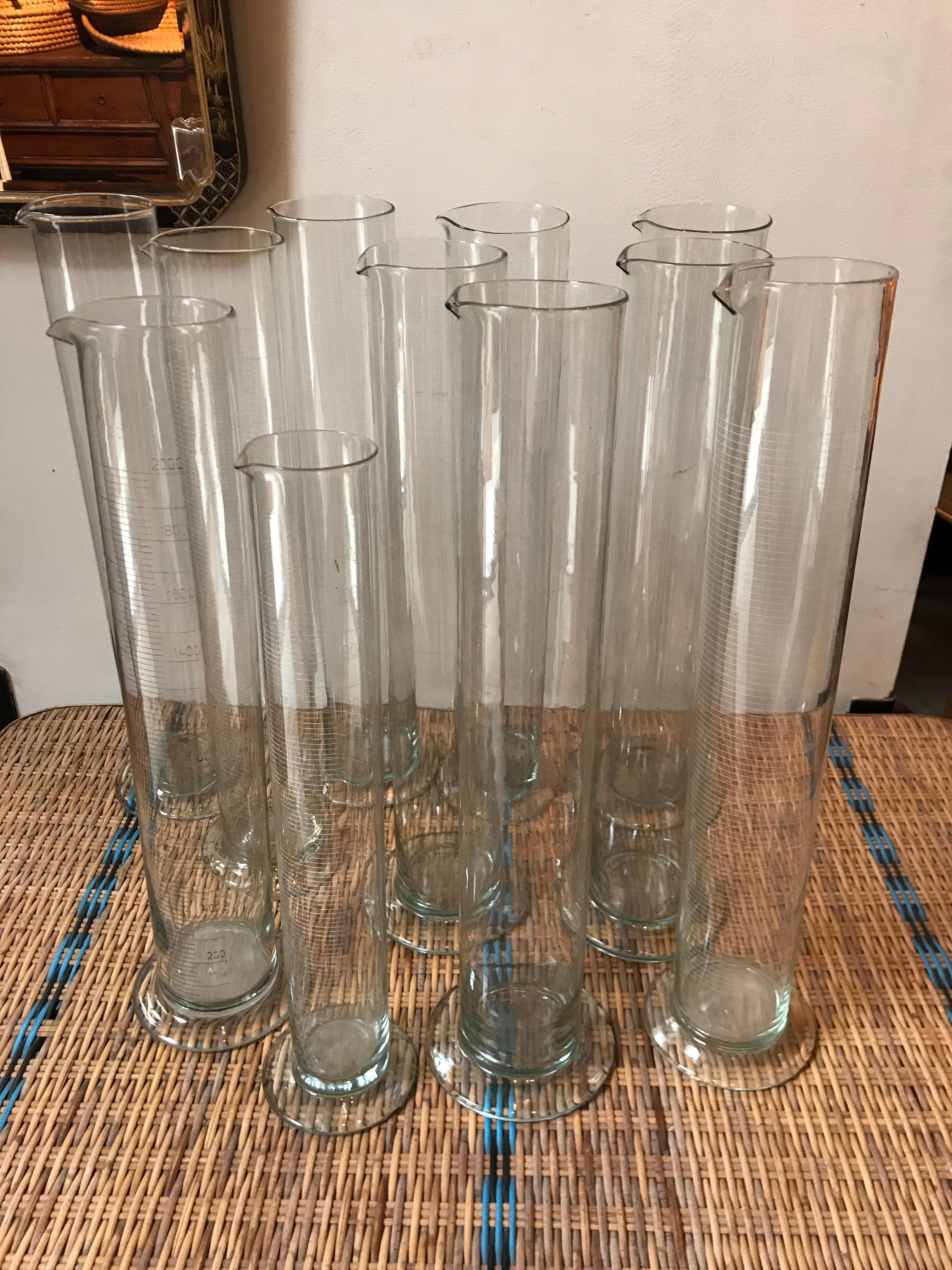 Belgian hand blown glass chemistry beakers are in excellent condition and ready to use as vases. The heavy glass foot makes the vessels very stabile in spite of the height. Use alone or in groups.
total of 11 available=
7 clear
3 with marking