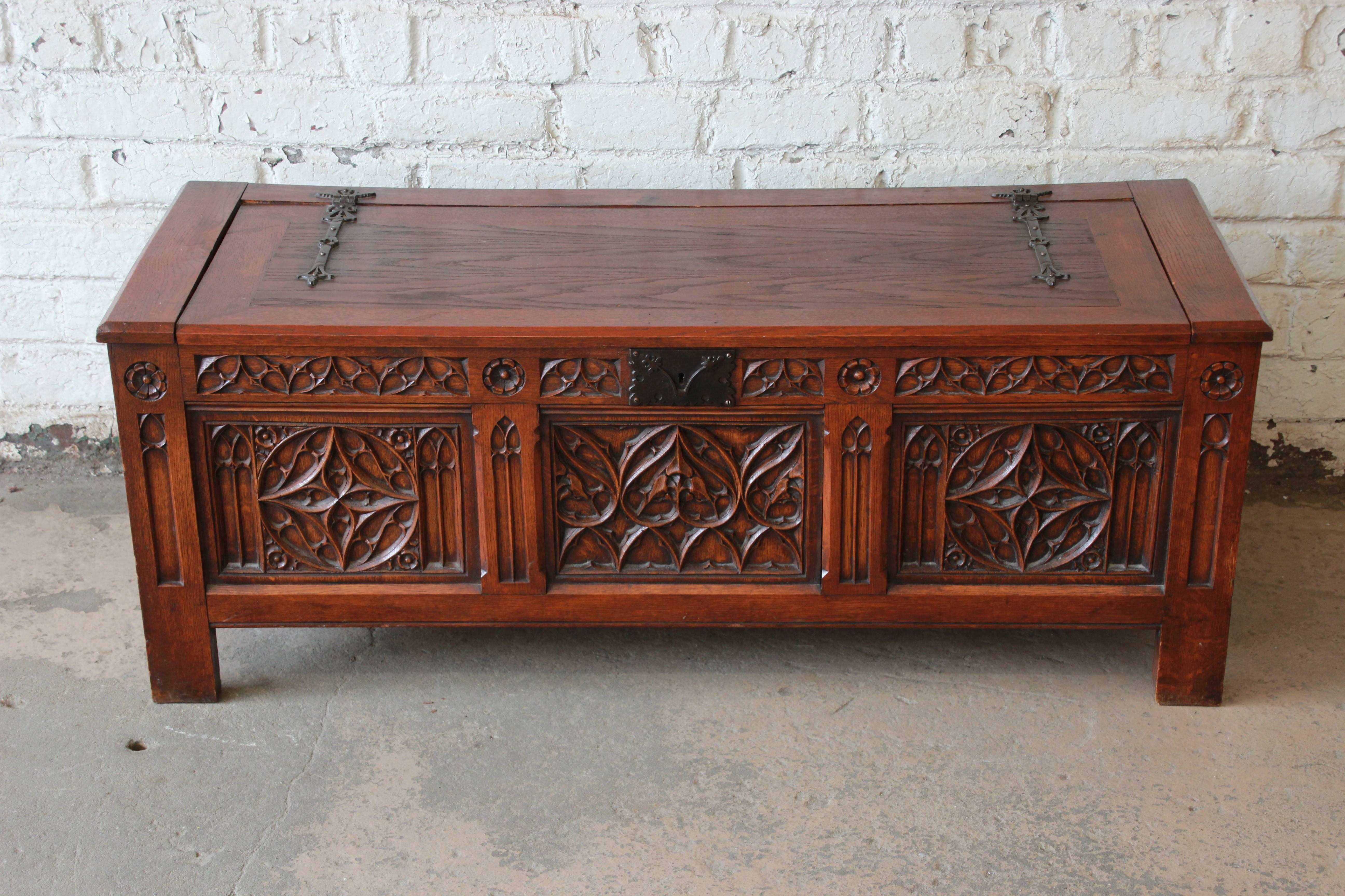 An exceptional Belgian Gothic Revival carved oak blanket chest or coffer. The chest features beautiful Gothic carved wood details and solid oak construction. The top flips up on iron hinges to reveal an open chest inside. Marked 