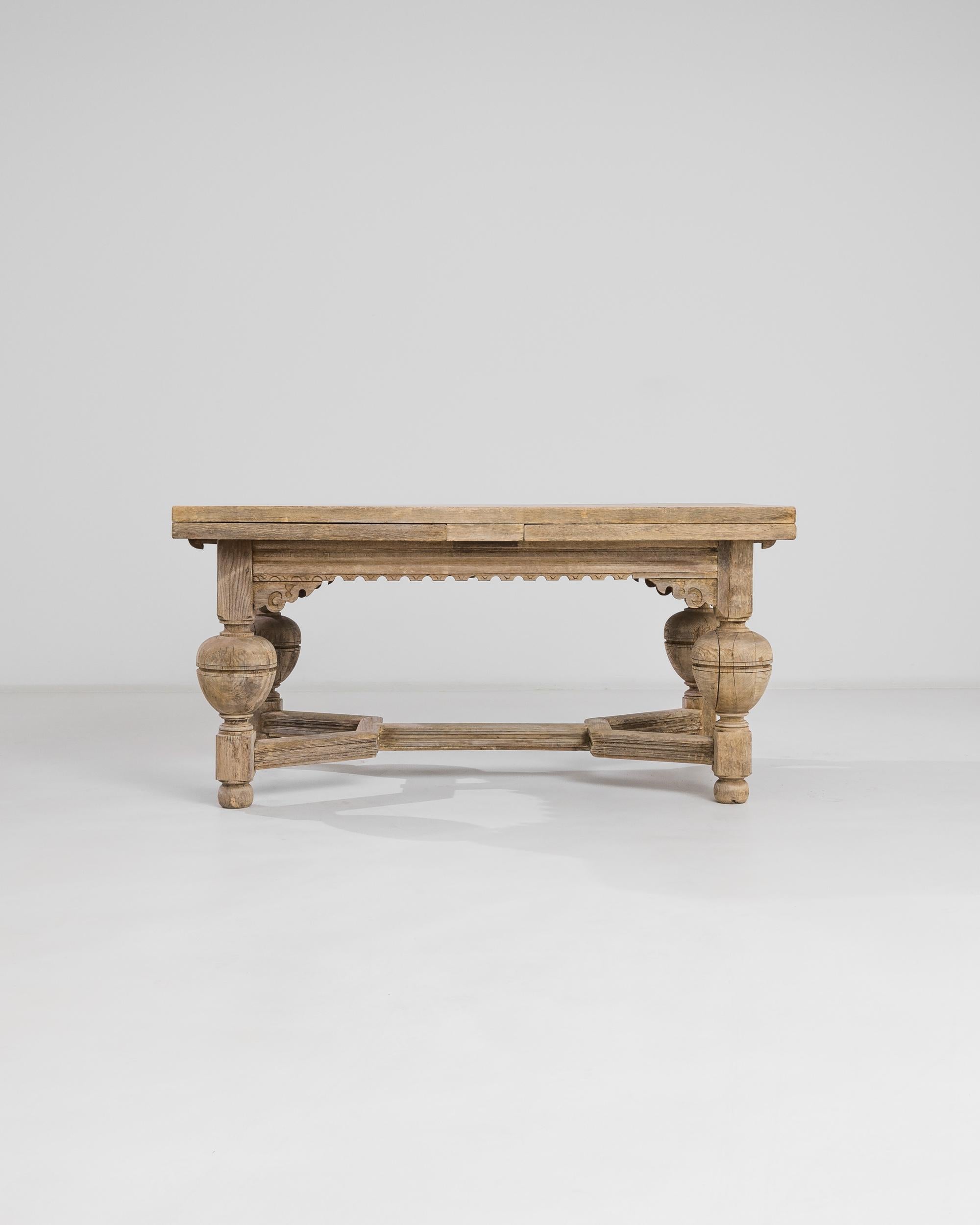 Staunch and sturdy, the statuesque proportions of this Neo Renaissance table are illuminated by the sunlit tone of the restored oak. Made in Belgium at the turn of the century, urn-shaped legs and a geometric stretcher create a stately silhouette,