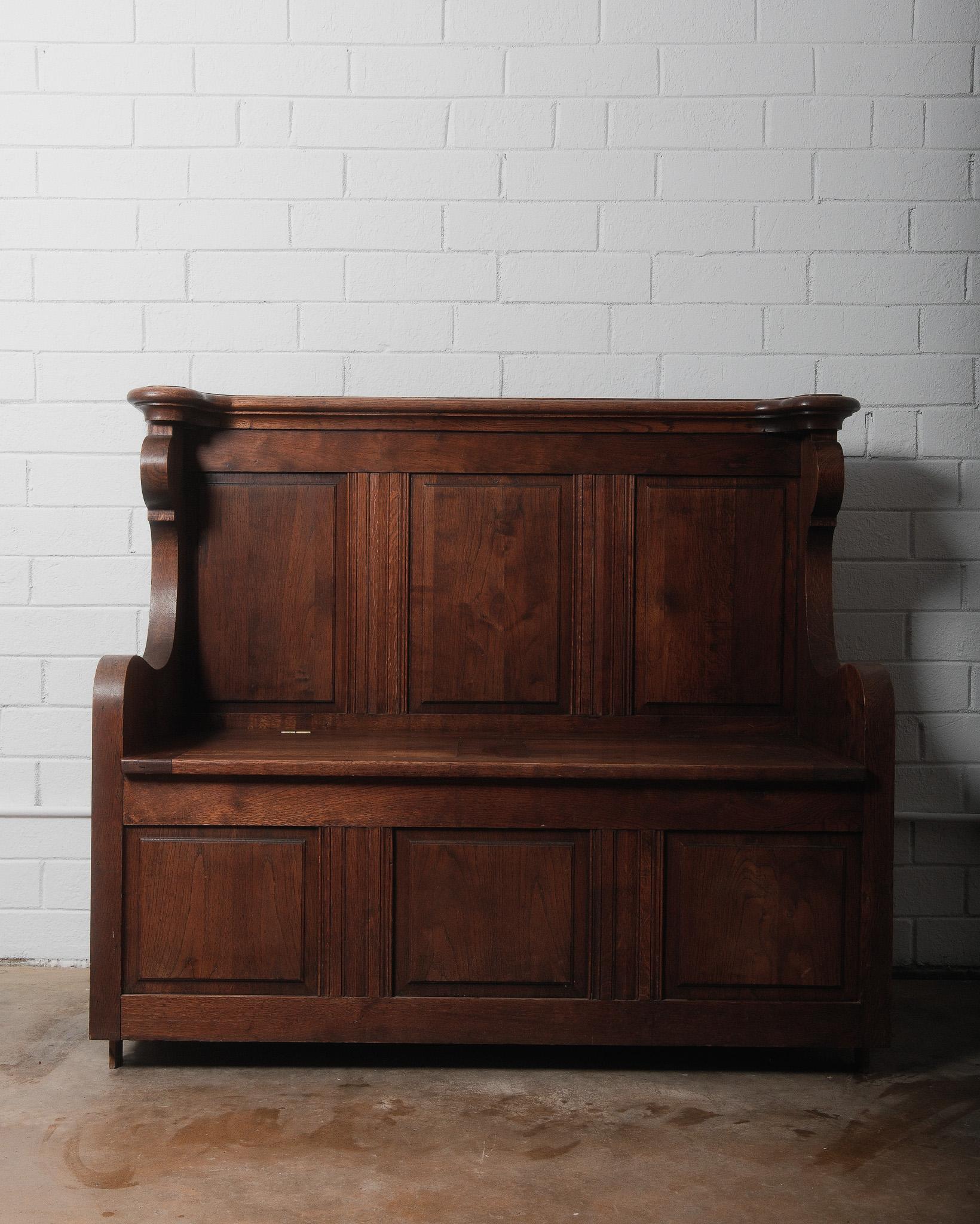 This Antique Belgian Oak Settle Bench is a stunning example of early 20th-century craftsmanship, featuring a beautifully sculpted and intricately carved silhouette. Solidly built from rich, high-quality oak, it remains in good vintage condition,