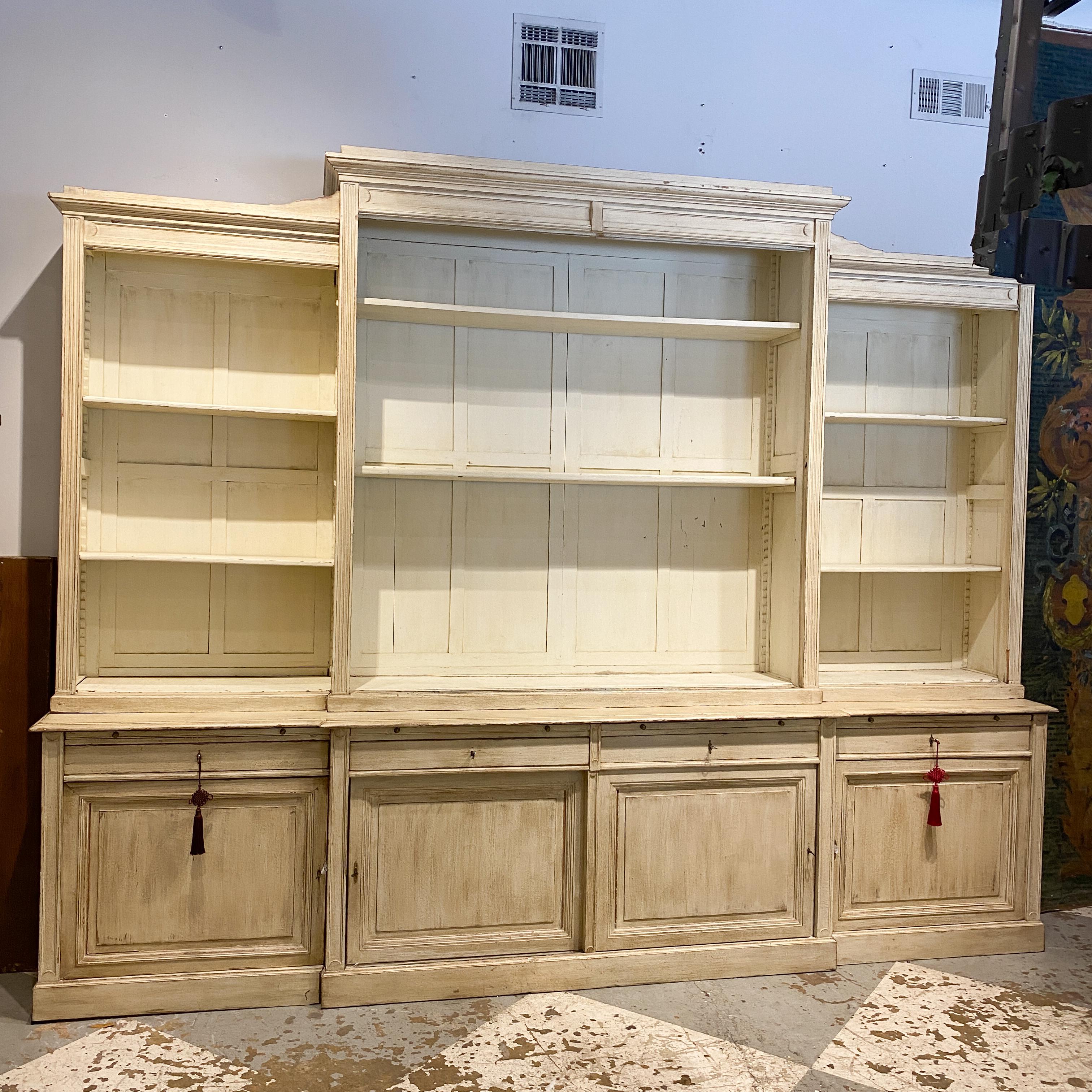 This is a large, antique oak Belgian display cabinet with ample storage and sliding glass doors, fabricated, circa 1910. The cabinet comes apart into multiple pieces and once assembled, appears to be one solid piece of furniture. In just the right