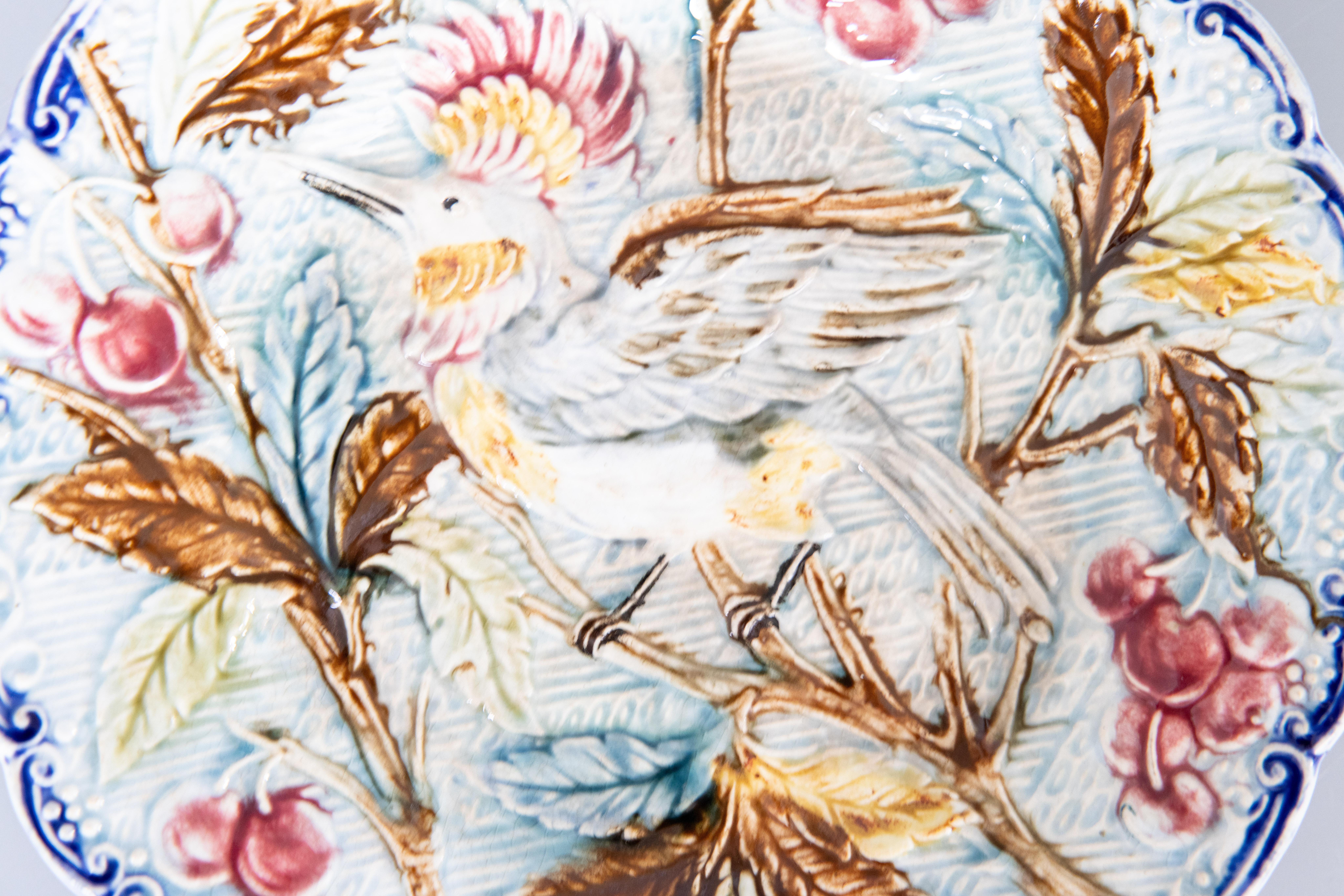 Ein prächtiger antiker belgischer Majolikateller mit einem Vogel in einem Kirschbaum, Wasmuel, um 1890. Dieser schöne handbemalte Teller hat brillante, leuchtende Farben und exquisite Details.

ABMESSUNGEN
8ʺW × 1ʺD × 8ʺH